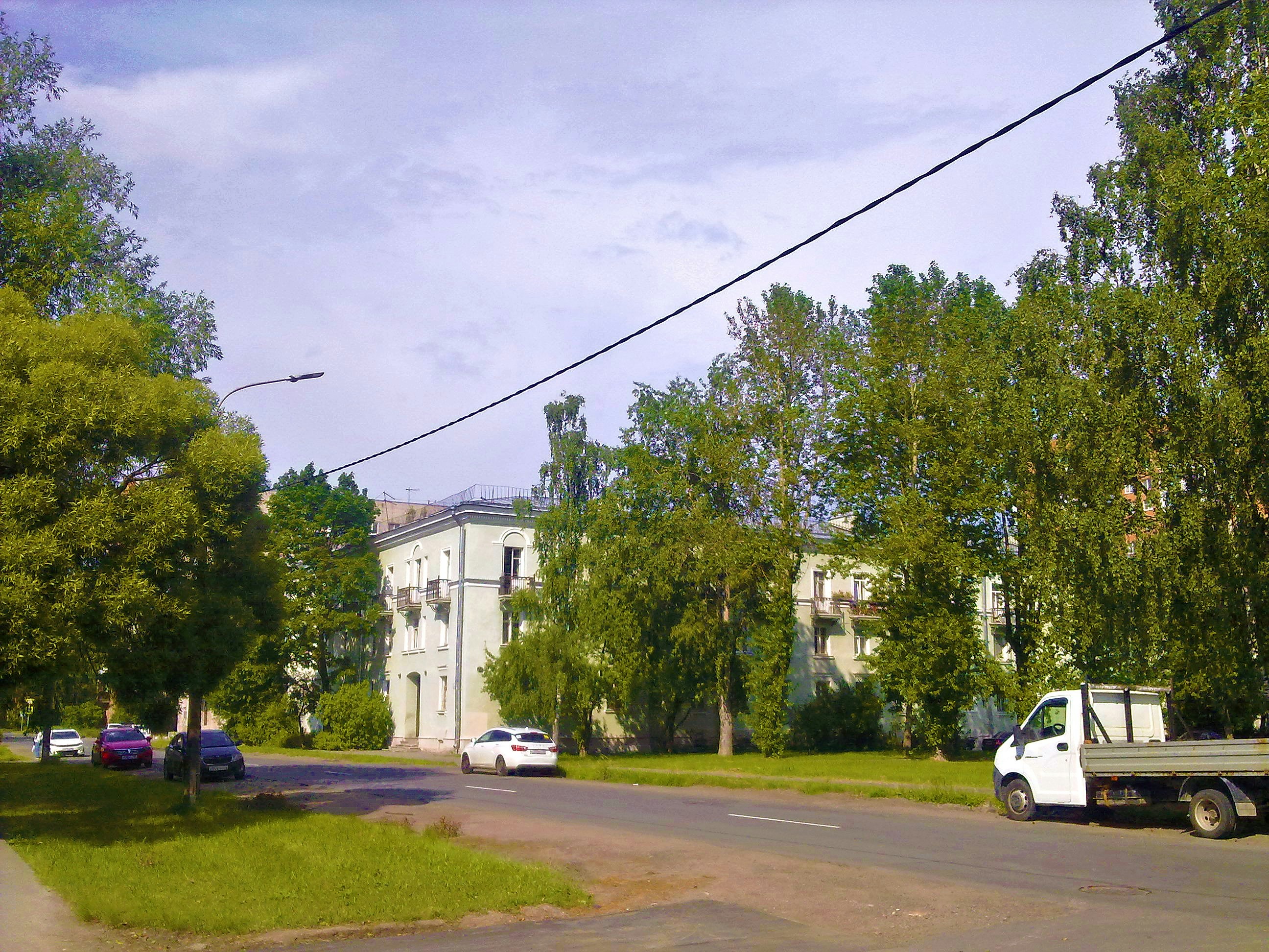 White building surrounded by lush green trees