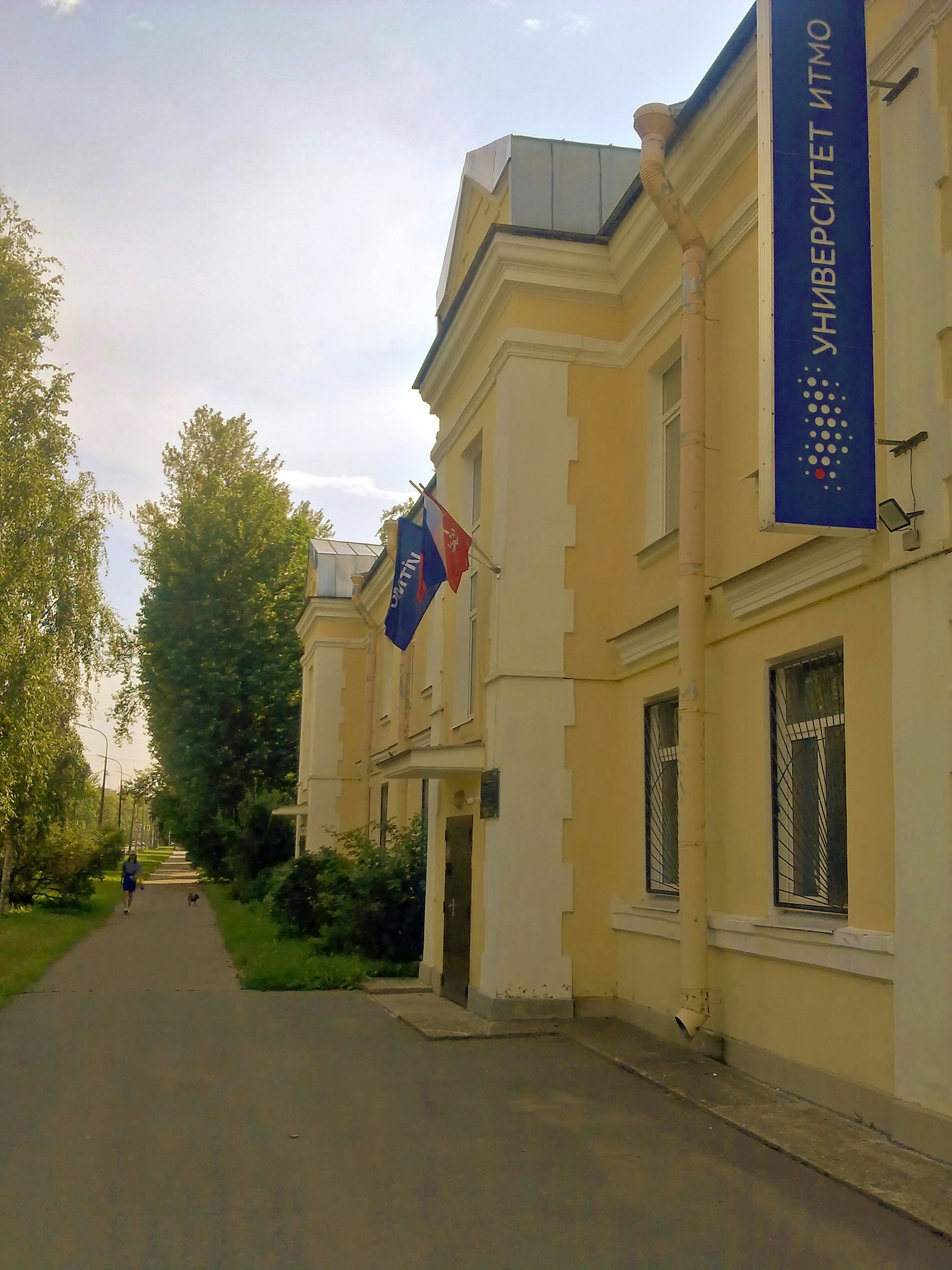 Yellow building with a blue banner and flags