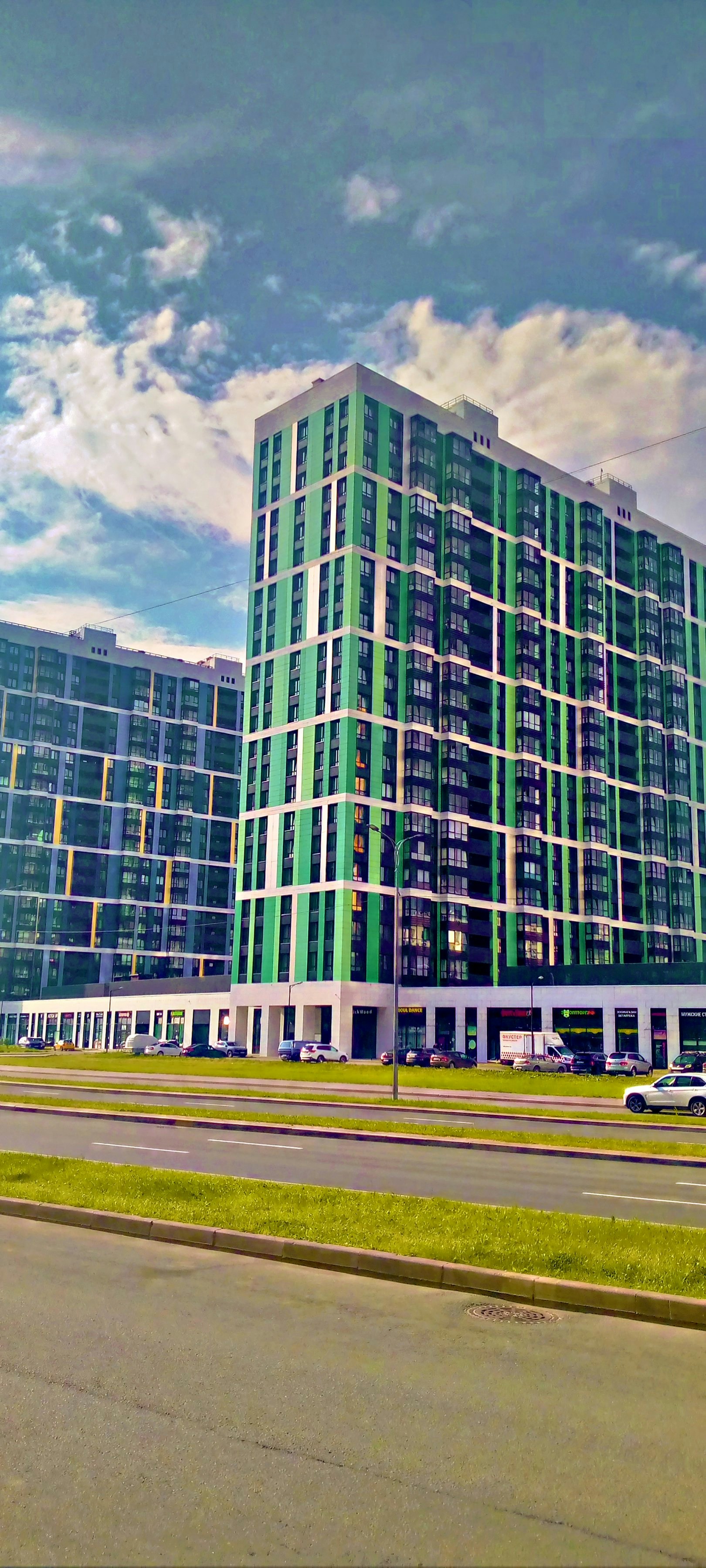 Modern apartment buildings with green and white facades.