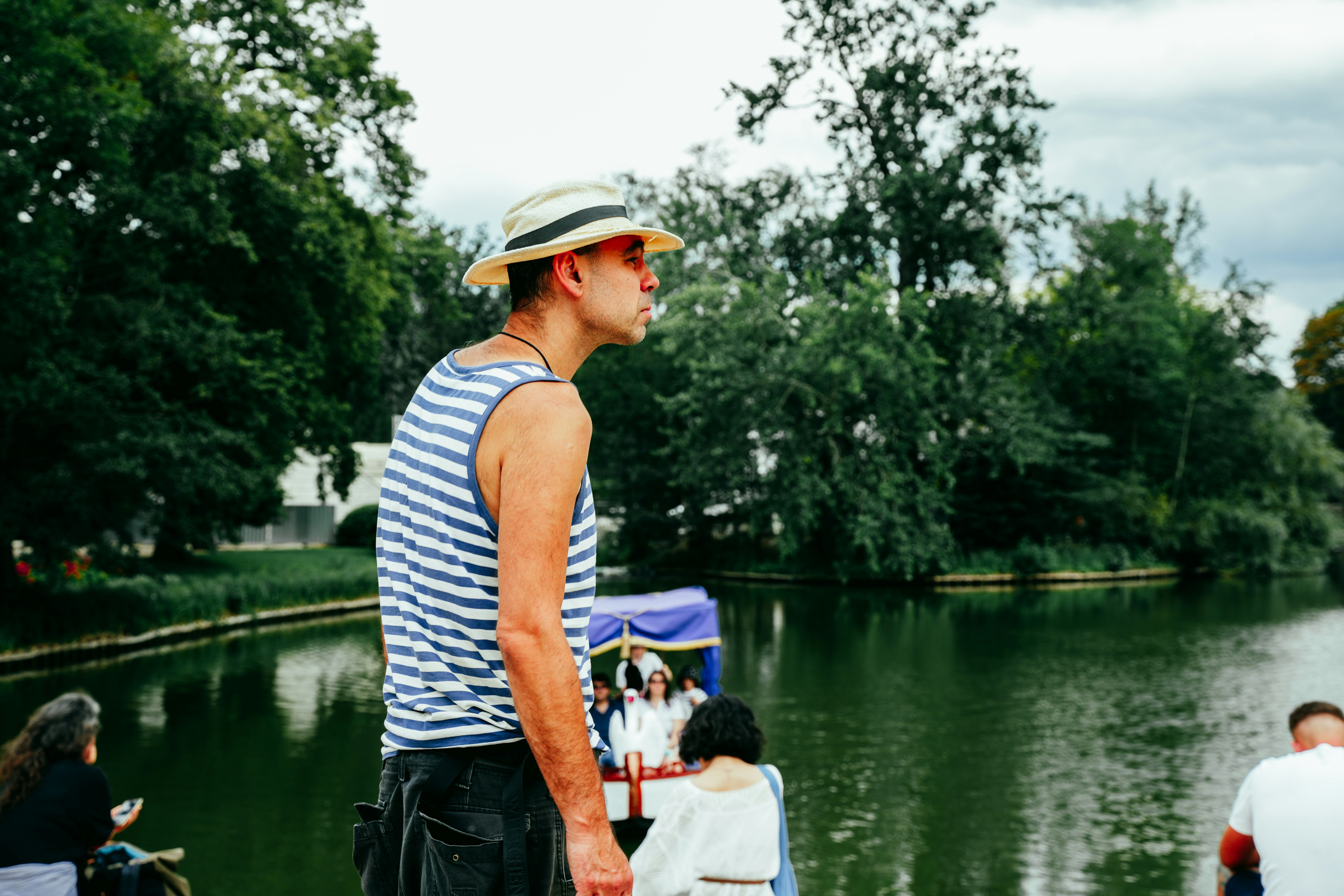 Man in striped shirt and hat by the water