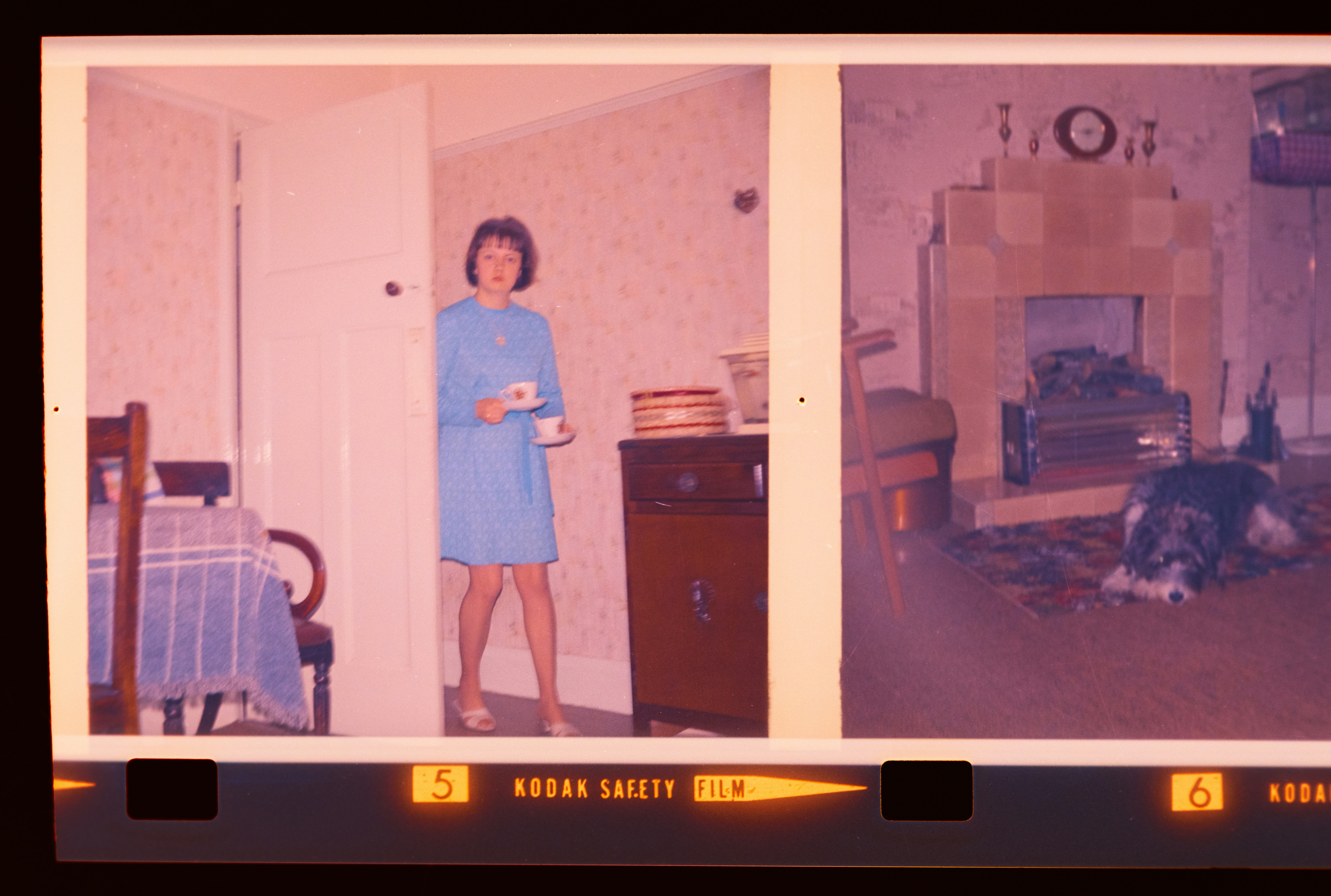 Woman holding cup in doorway near fireplace with person on floor (Photo by Annie Spratt on Unsplash)