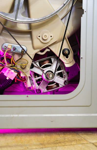 Close-up of washing machine motor and belt mechanism during a repair