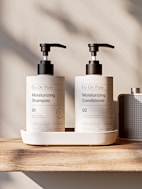 Two pump bottles of shampoo and conditioner on tray