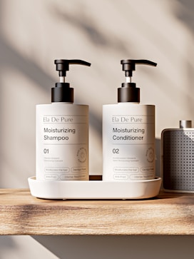 Two pump bottles of shampoo and conditioner on tray