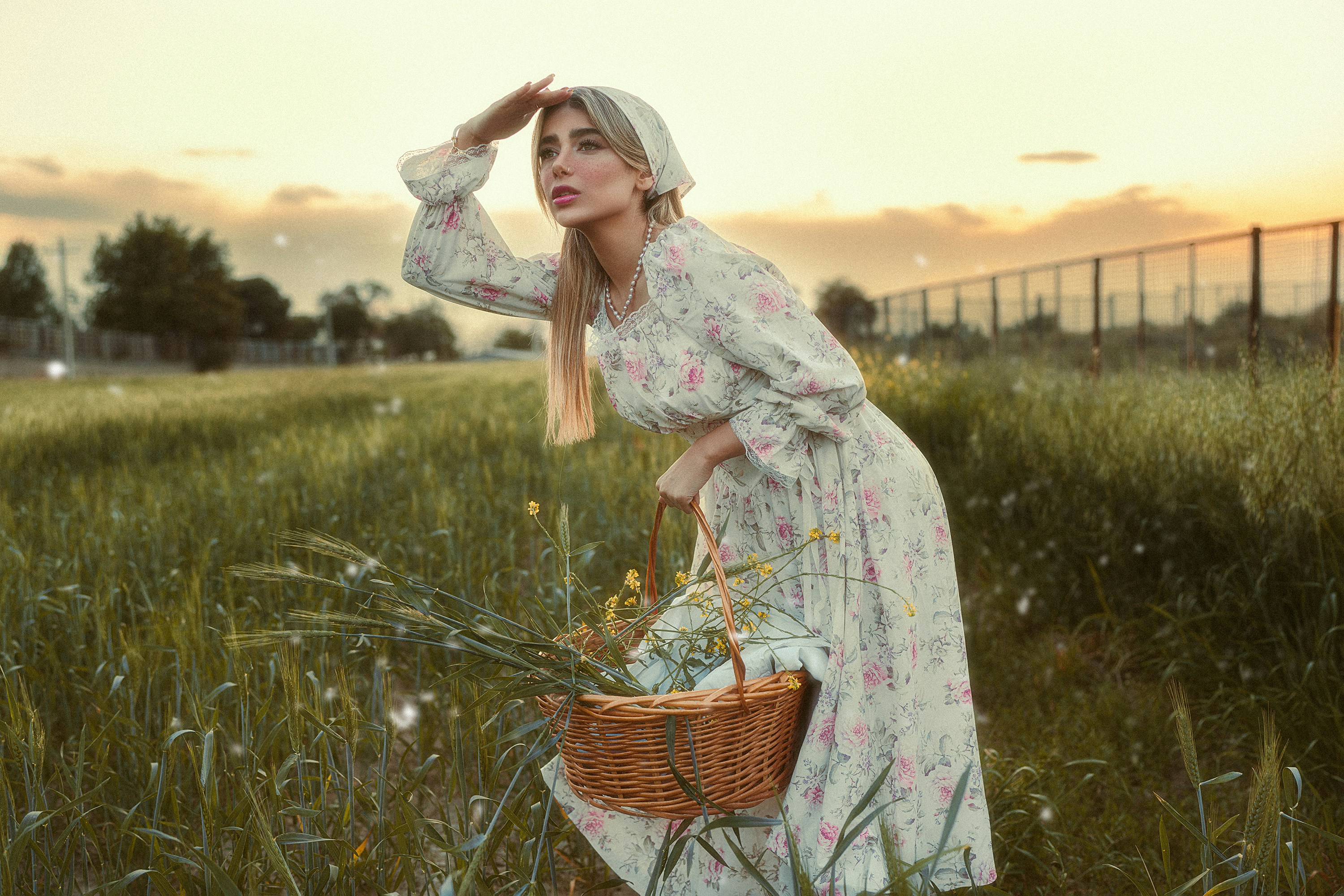 Femme en robe à fleurs avec panier regarde au loin