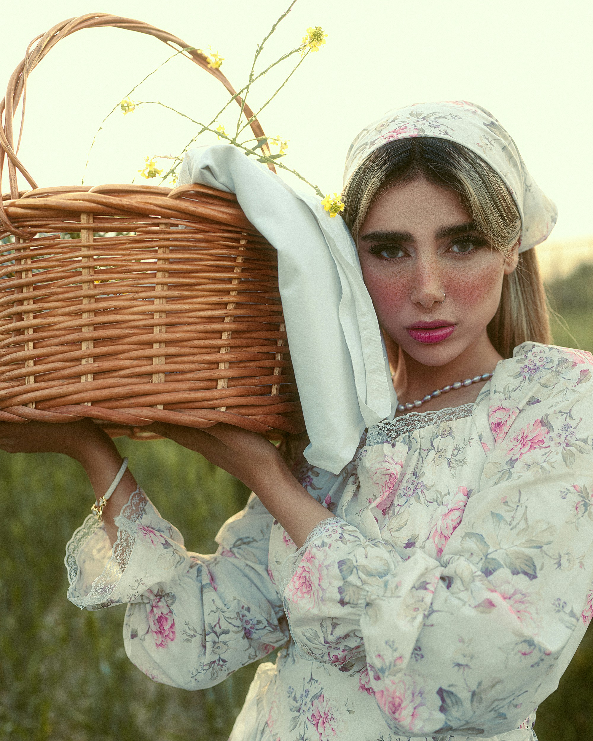 Femme en robe fleurie porte un panier en osier