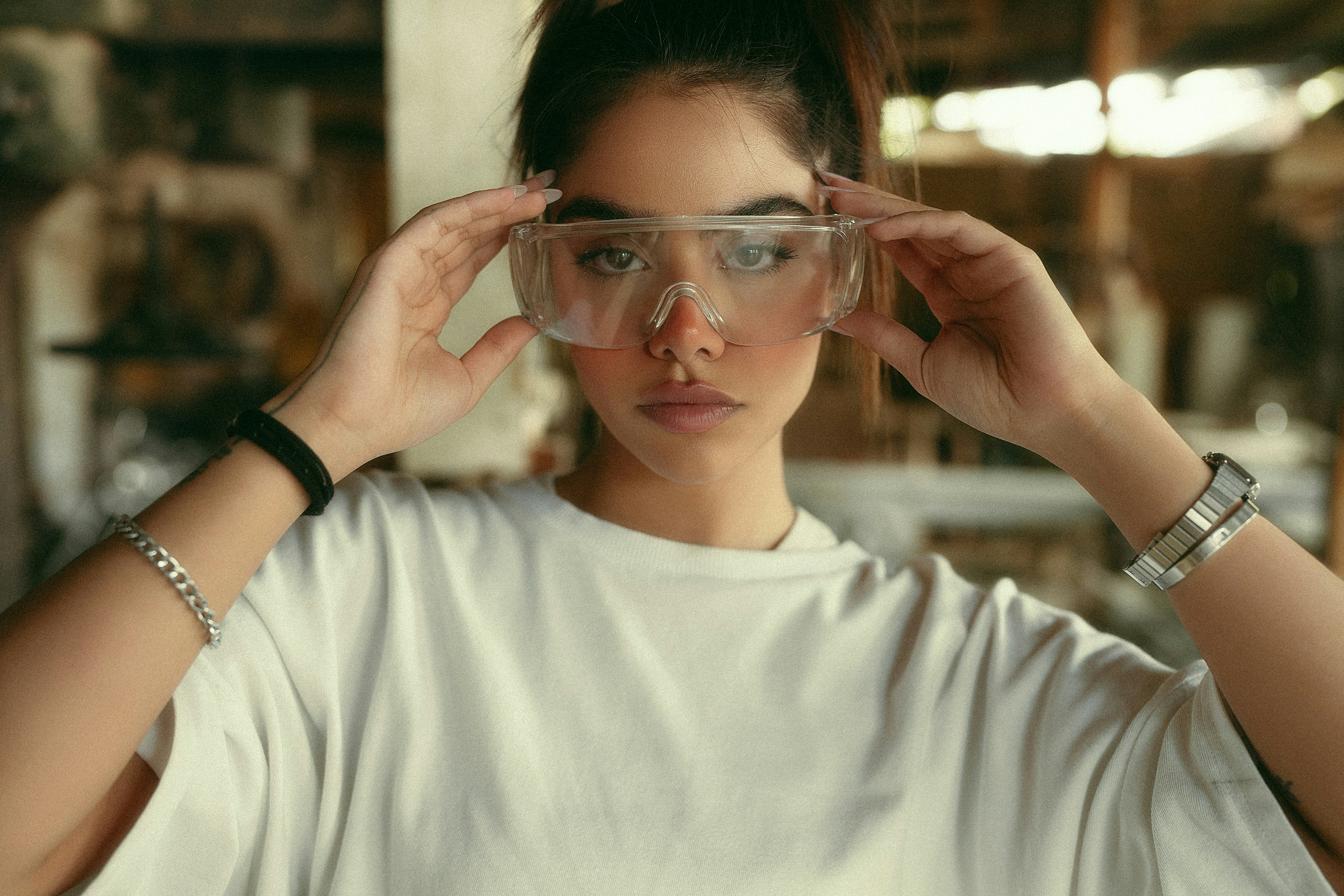 Jeune femme ajustant des lunettes de sécurité en atelier