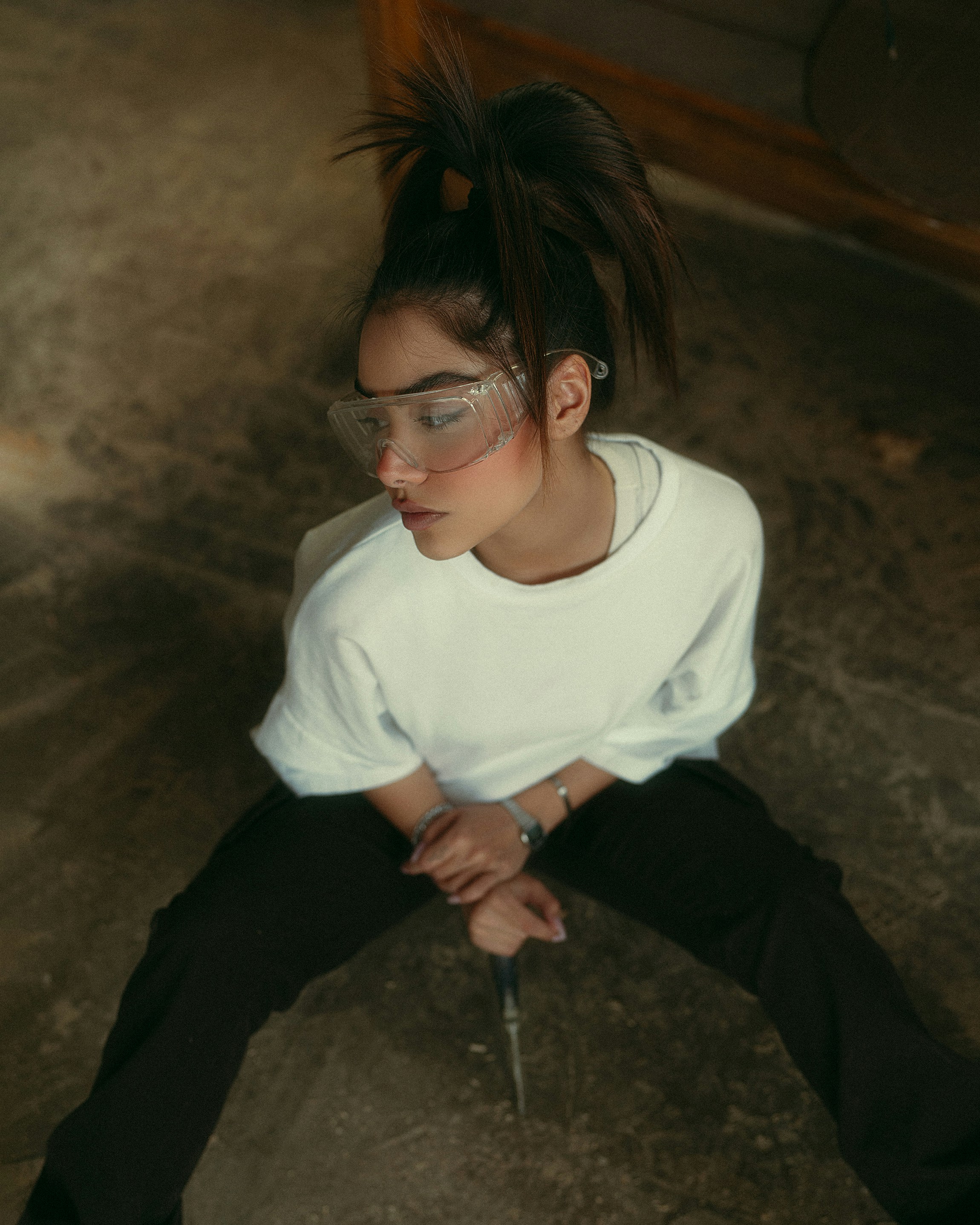 Jeune femme portant des lunettes de sécurité avec les mains jointes