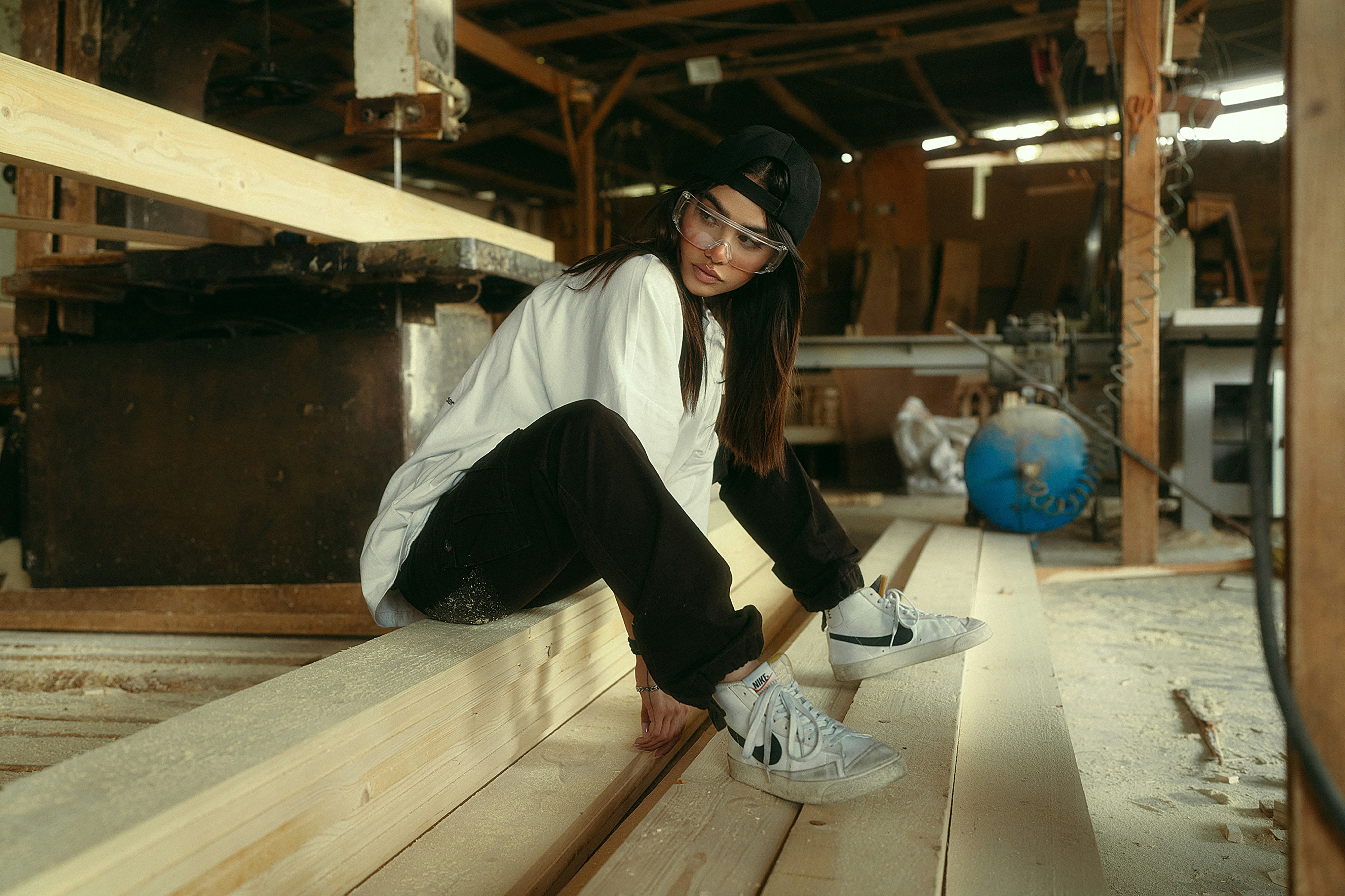 Jeune femme assise sur du bois dans un atelier