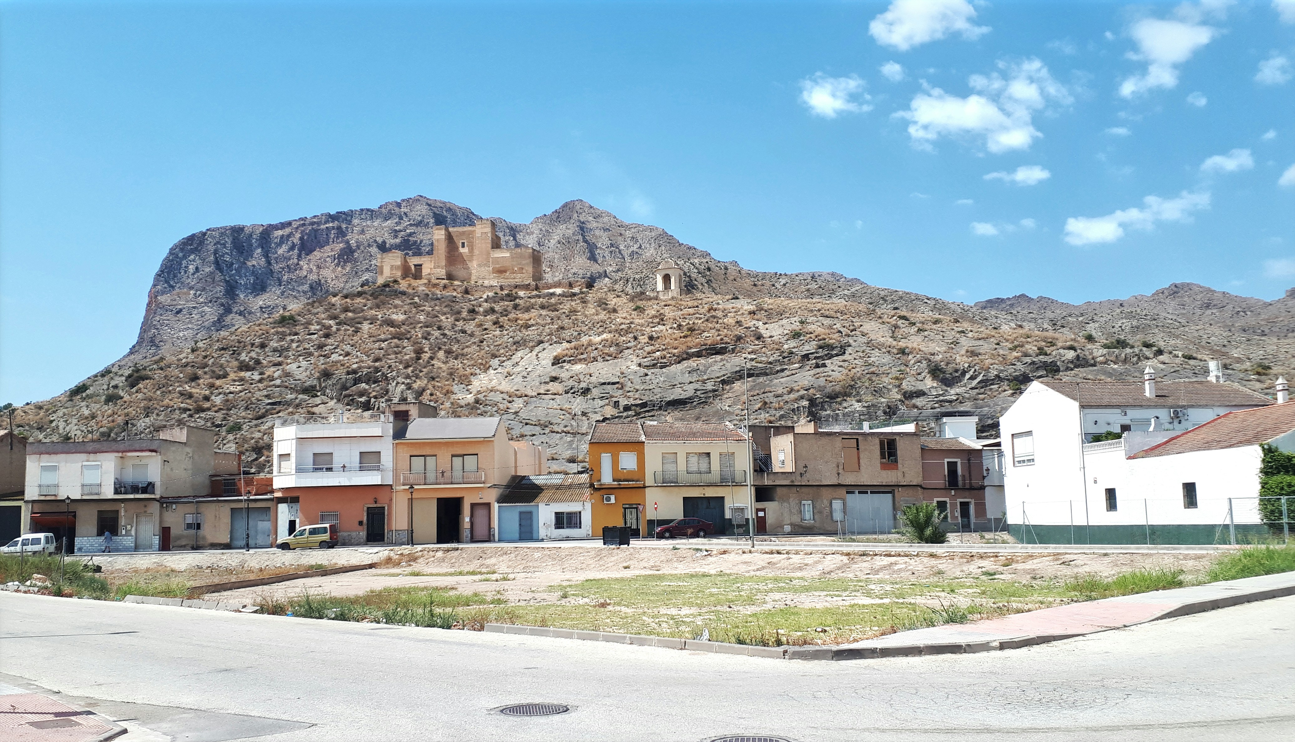 Small town nestled at the base of a large mountain.