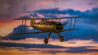 Biplane flying through dramatic clouds at sunset