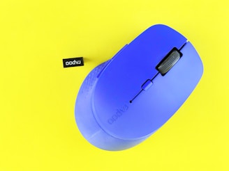 Blue computer mouse and usb receiver on yellow background