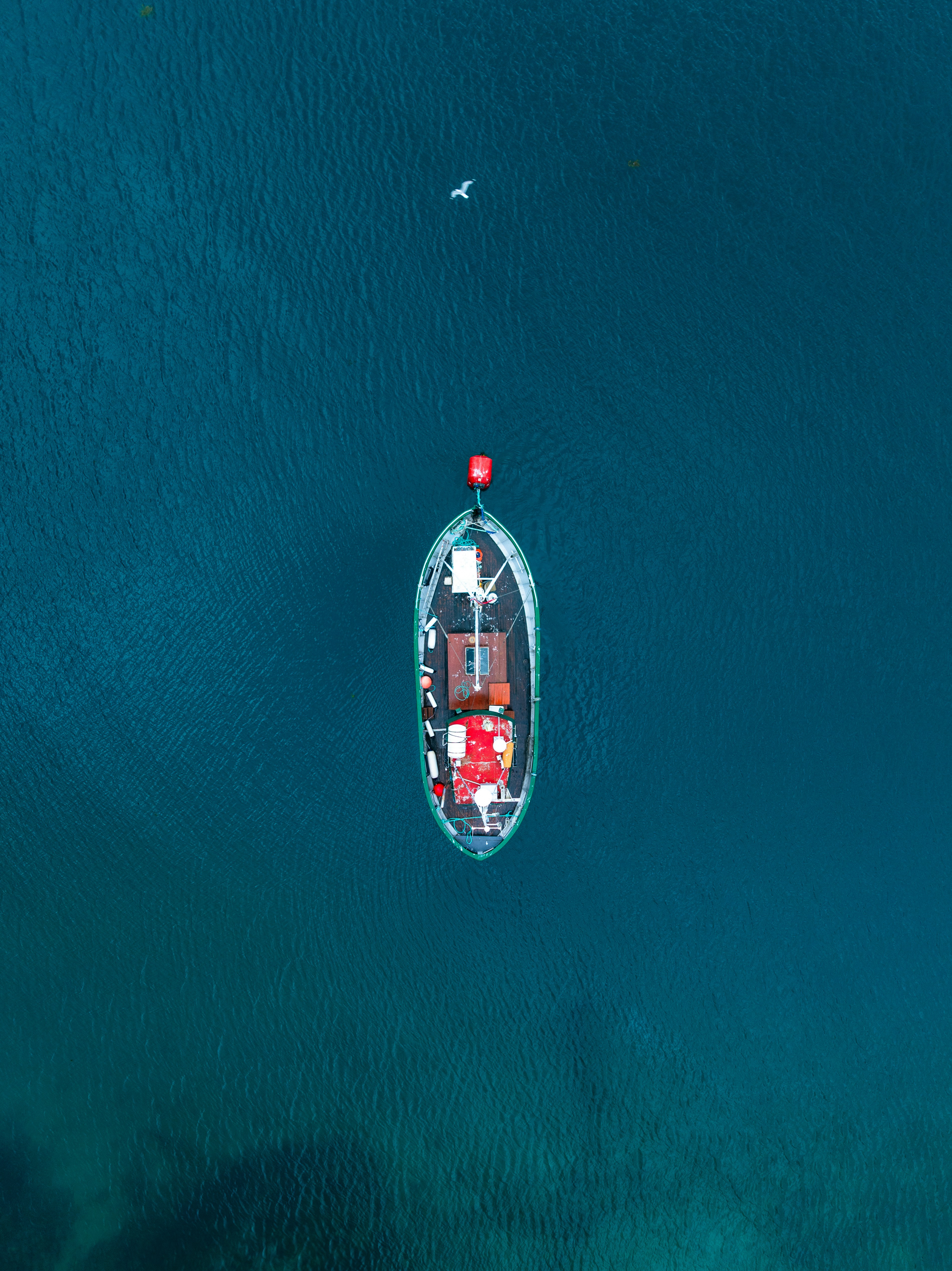 Aerial view of a single boat on blue water