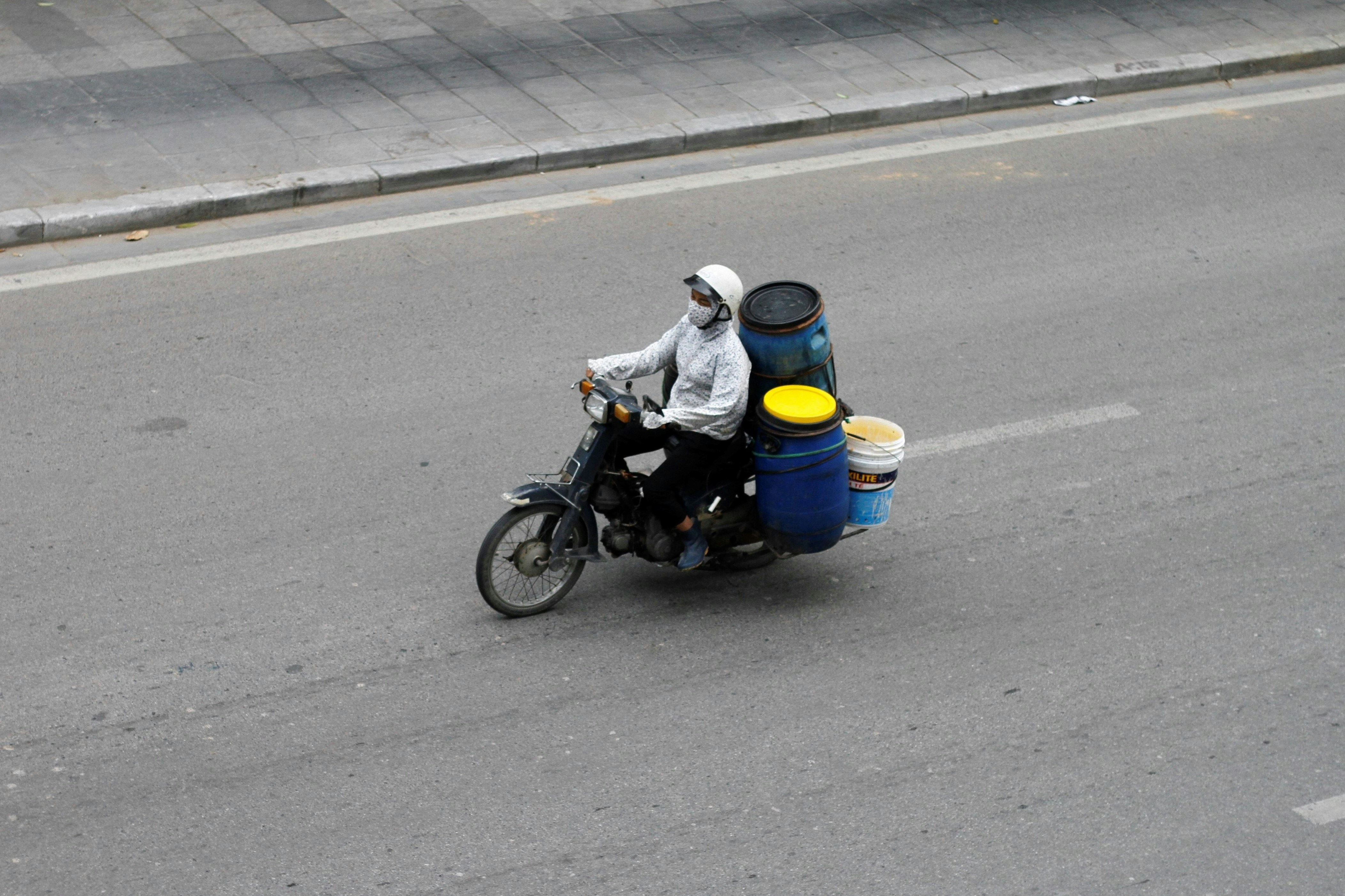 Person riding a scooter with luggage on a road