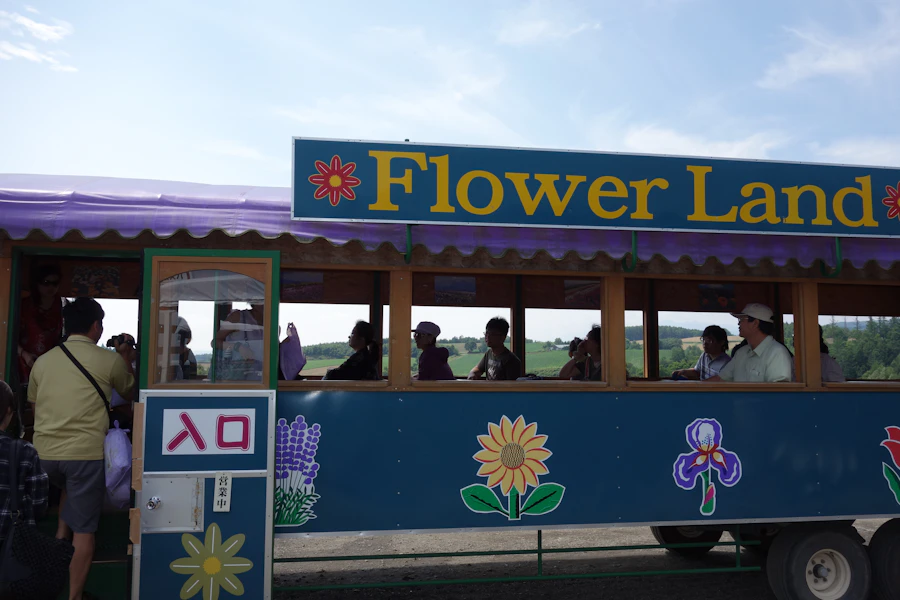 A large parade float decorated entirely with fresh tropical flowers and green foliage
