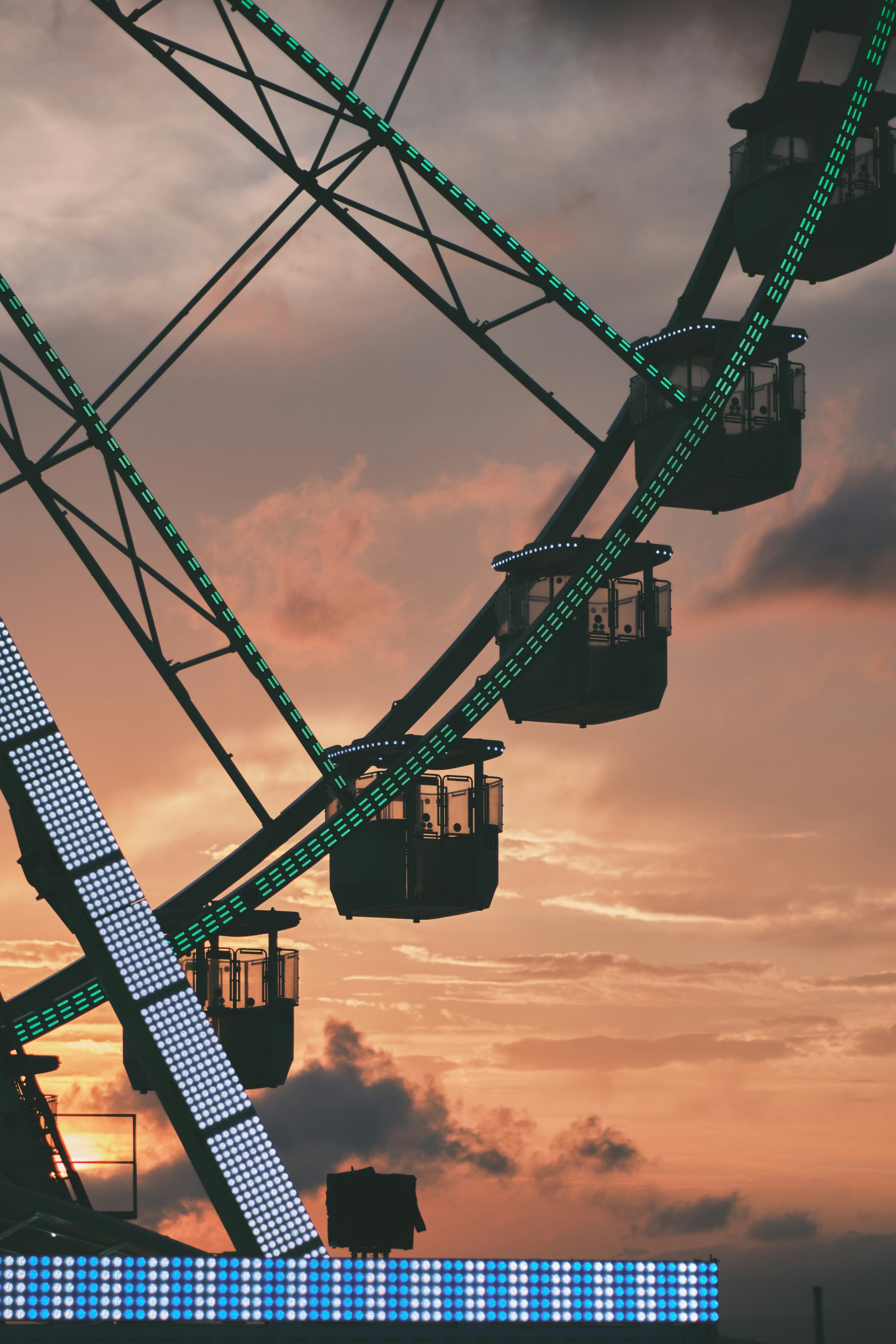 Ferris wheel illuminated against a sunset sky