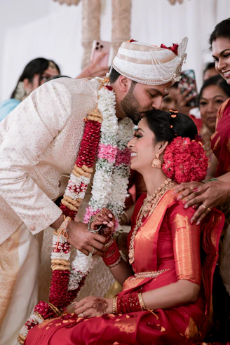 Groom kisses bride during traditional indian wedding ceremony.