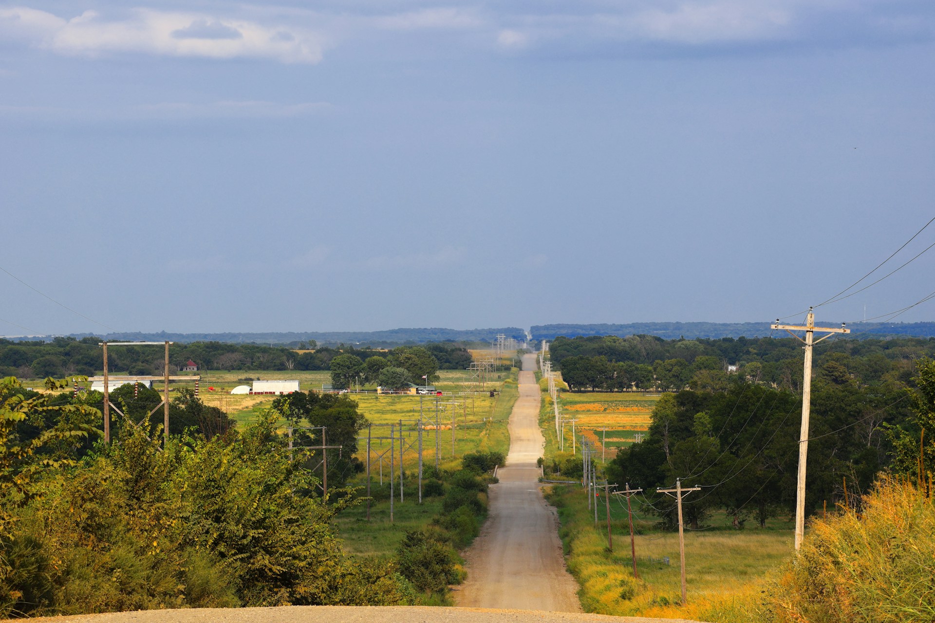 Long dirt road stretching through green countryside