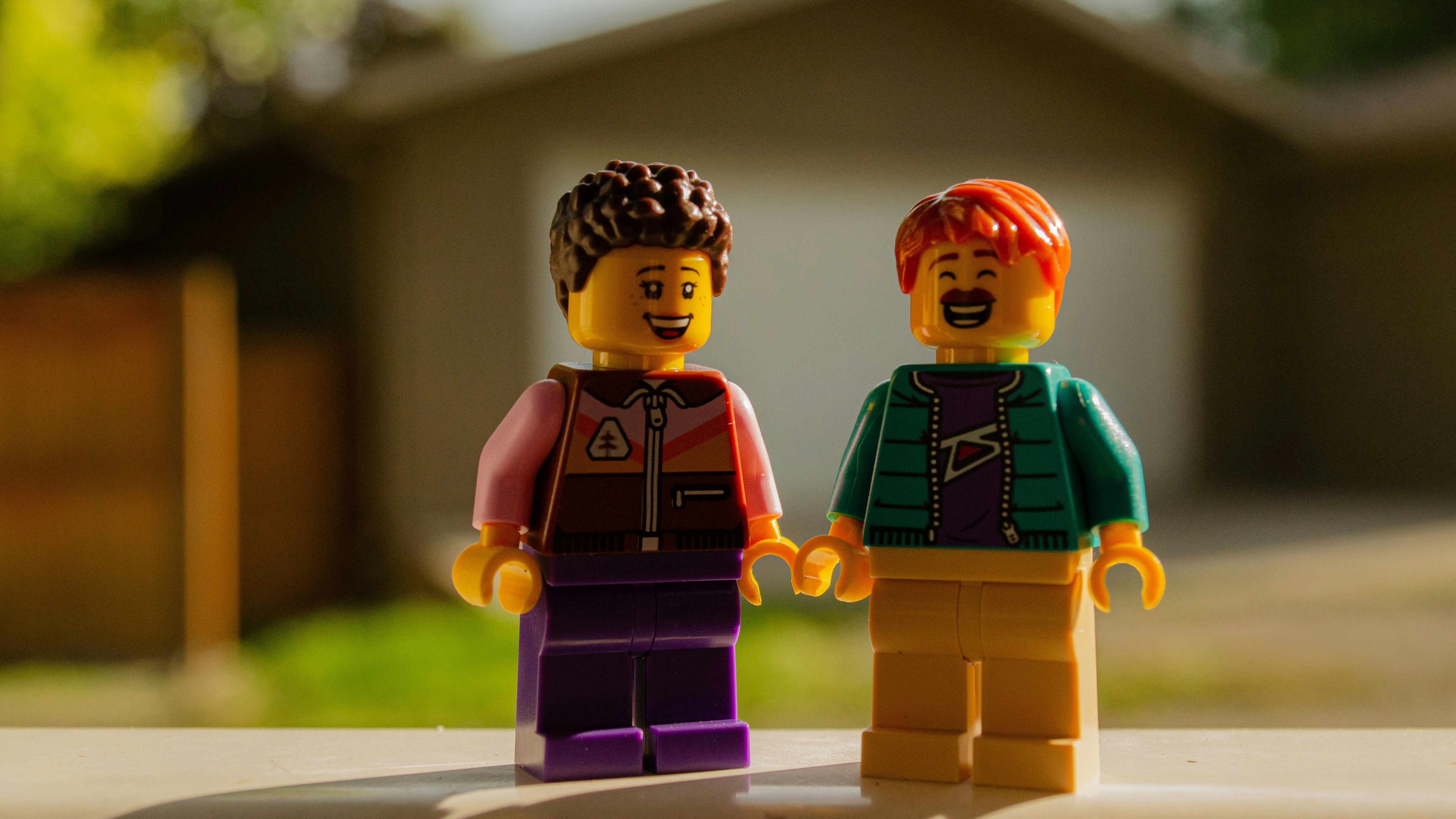 Duas figuras de lego de mãos dadas ao ar livre