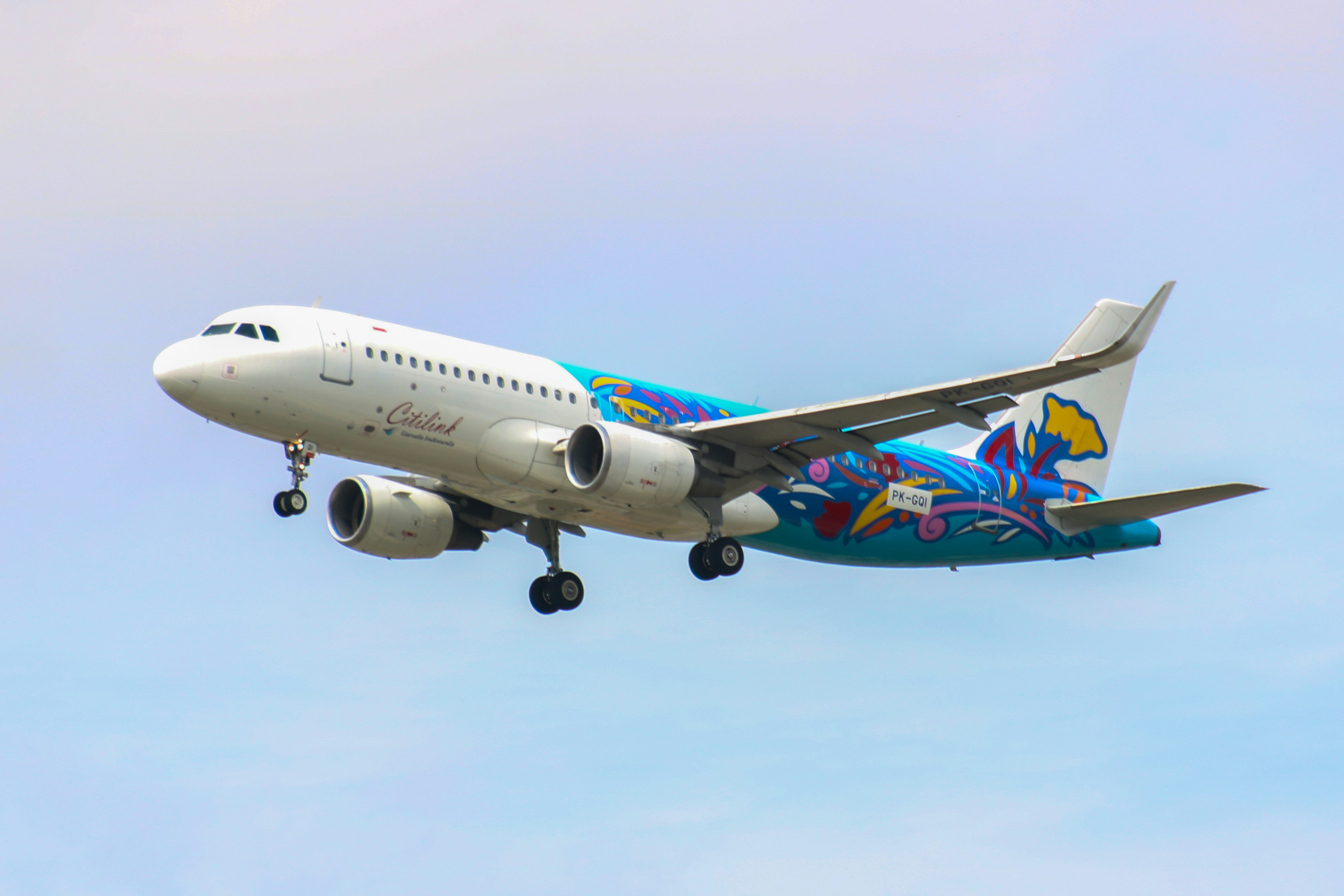 Airplane with colorful livery taking off against a blue sky