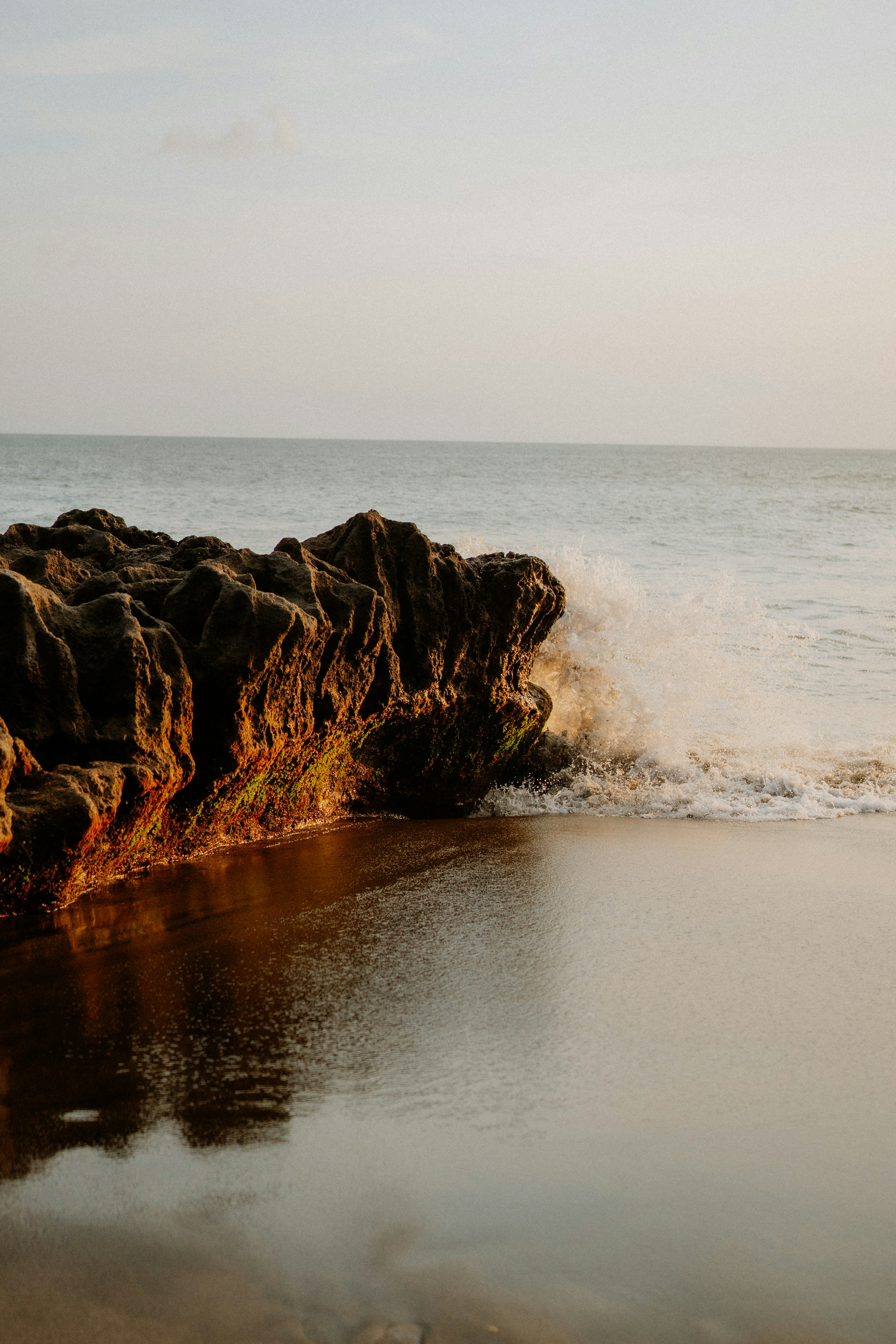 Waves crash against rocks on a serene beach
