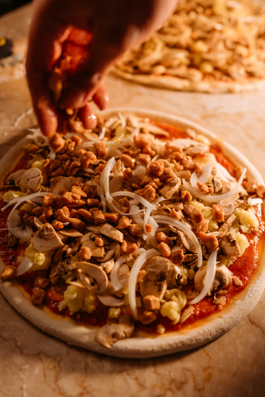 Chef ajoutant les garnitures sur une pizza