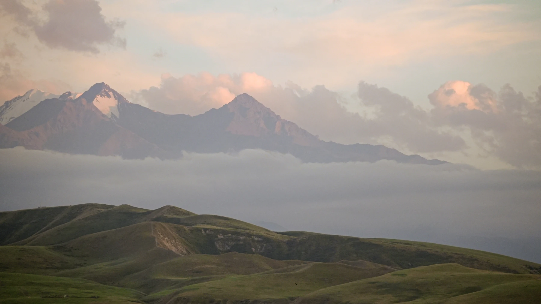 Misty mountain ridges and rolling hills at sunrise in Ala-Archa National Park