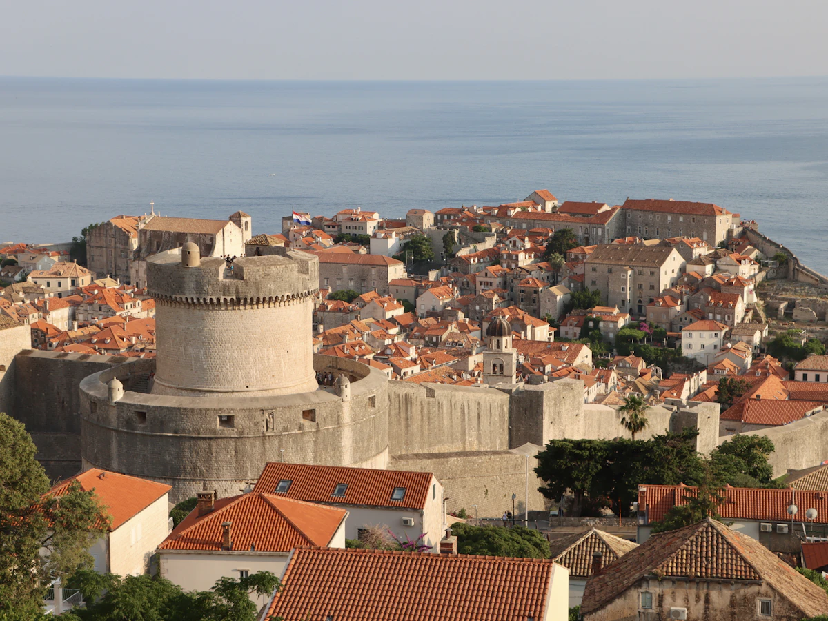 Dubrovnik Old Town red terracotta rooftops viewed from the ancient city walls with the Adriatic Sea and Lokrum Island in the background