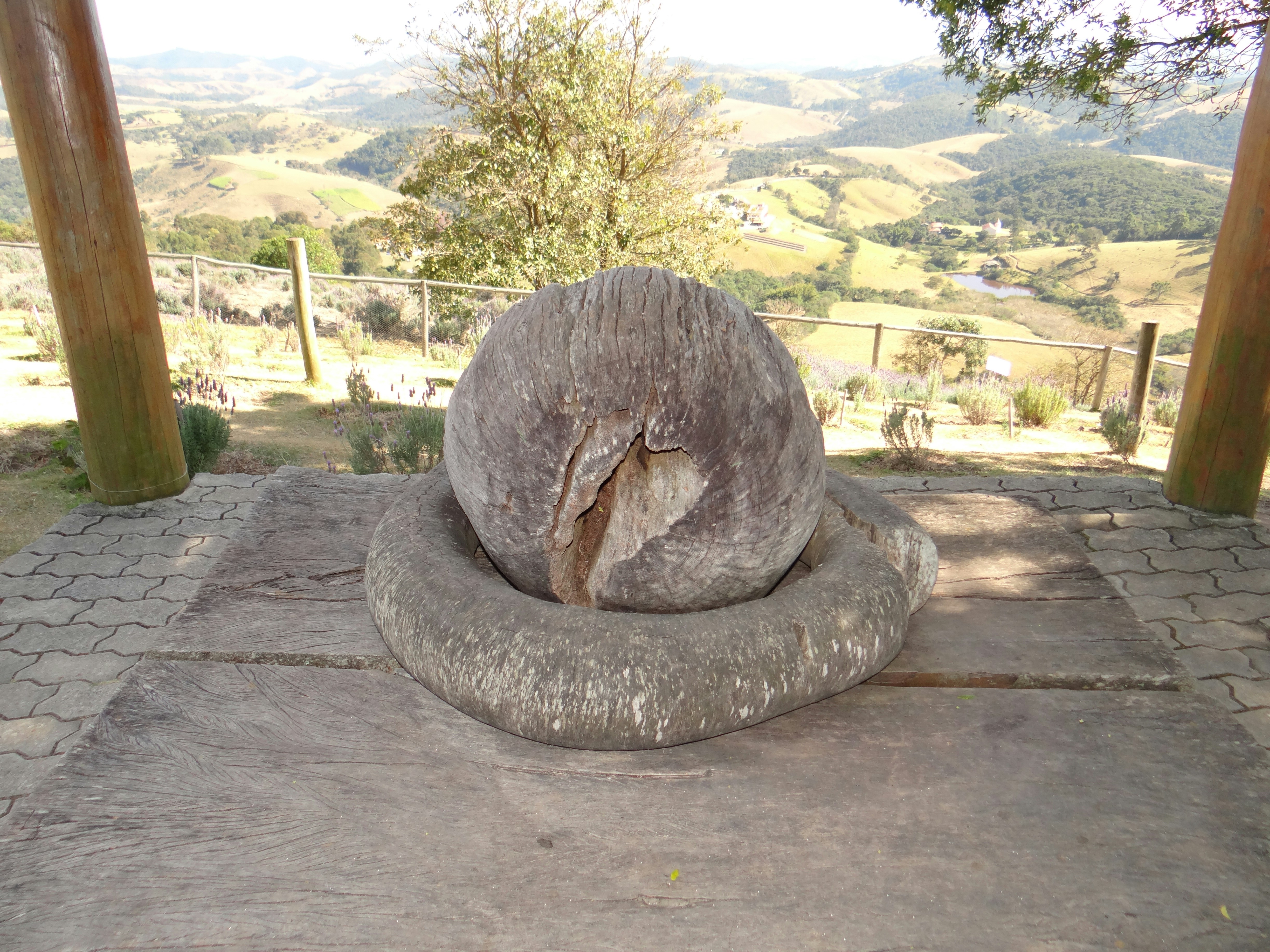 Stone sphere on a circular stone base outdoors.