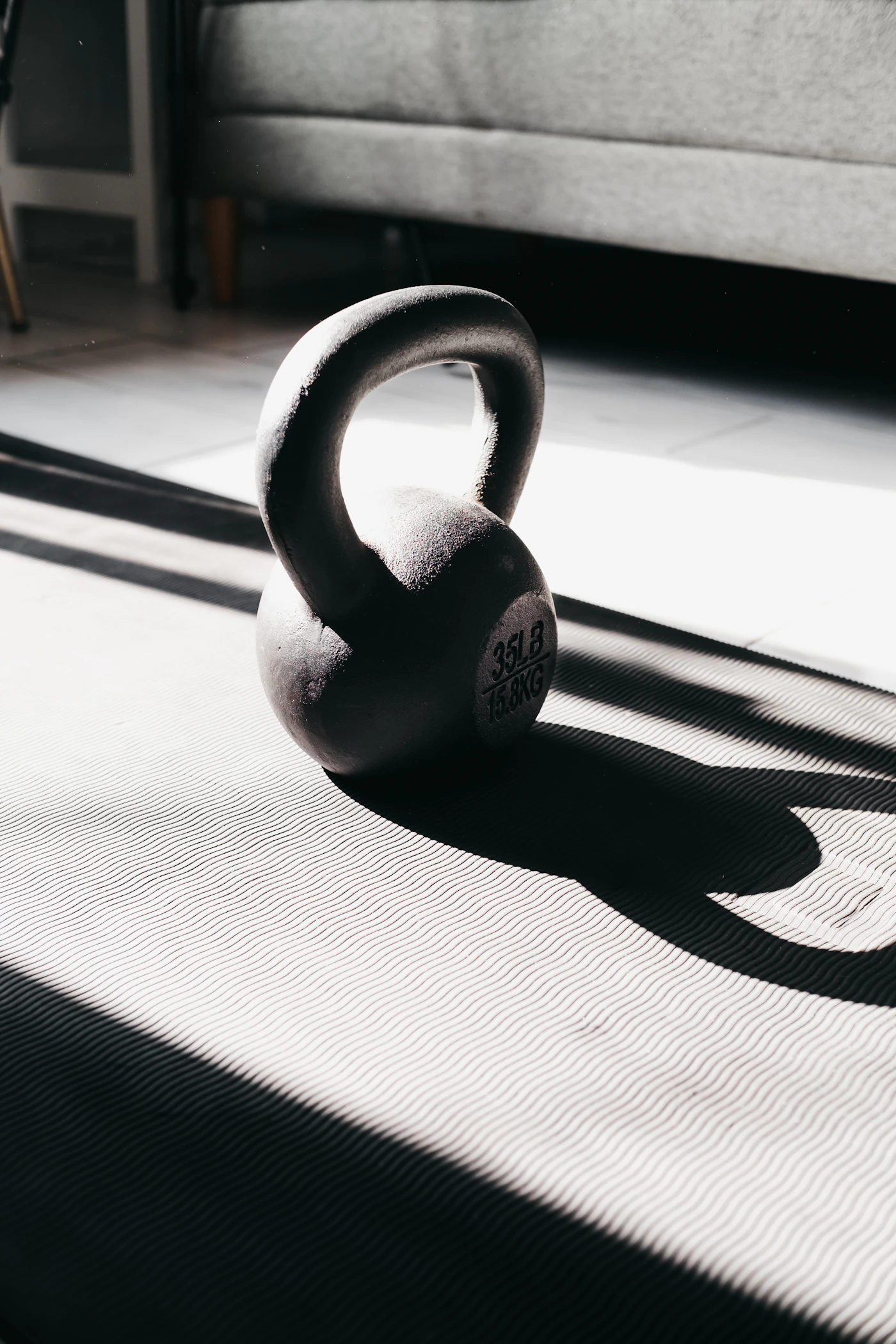 Kettlebell resting on a training mat in natural light