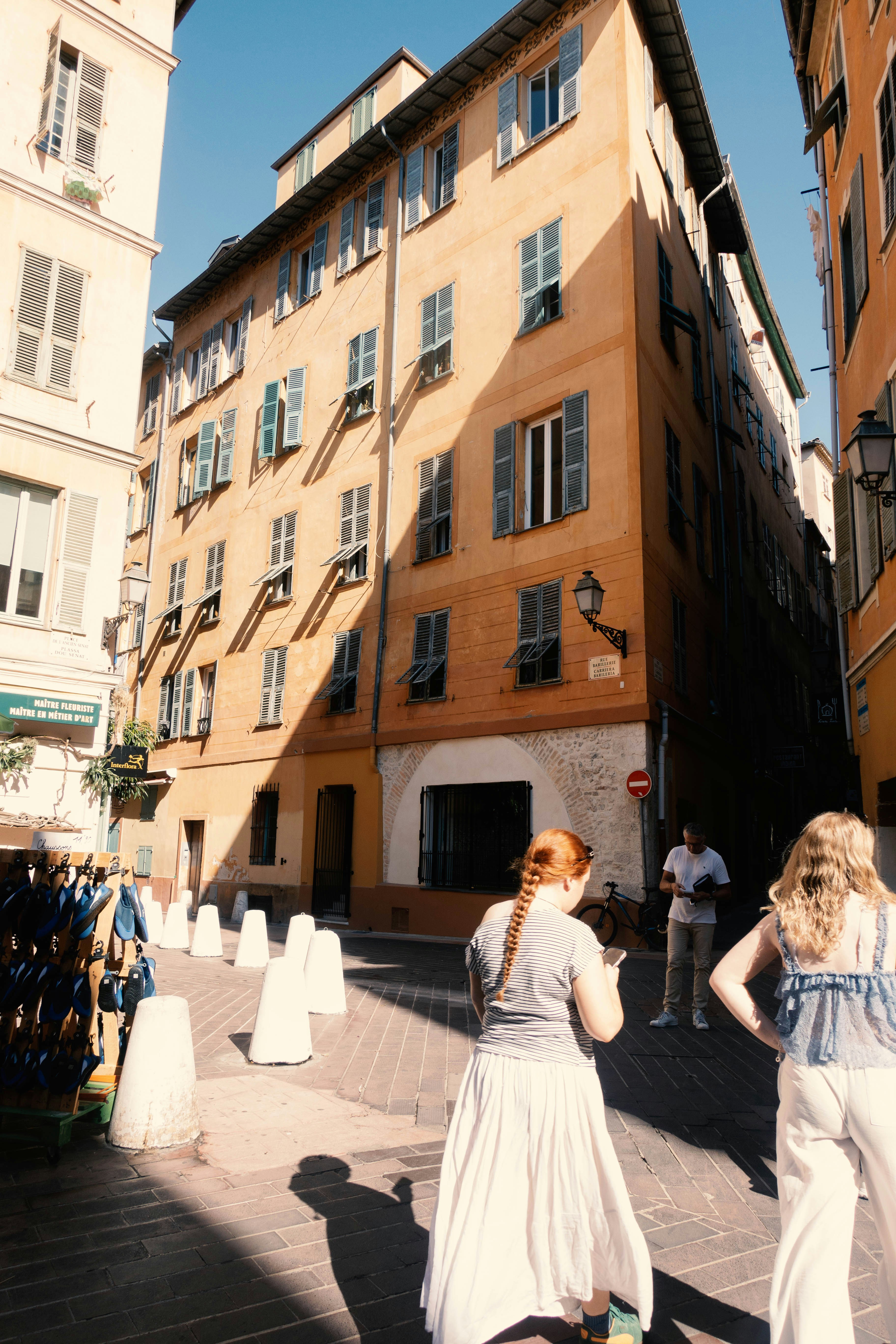 People walking on a sunny street with buildings