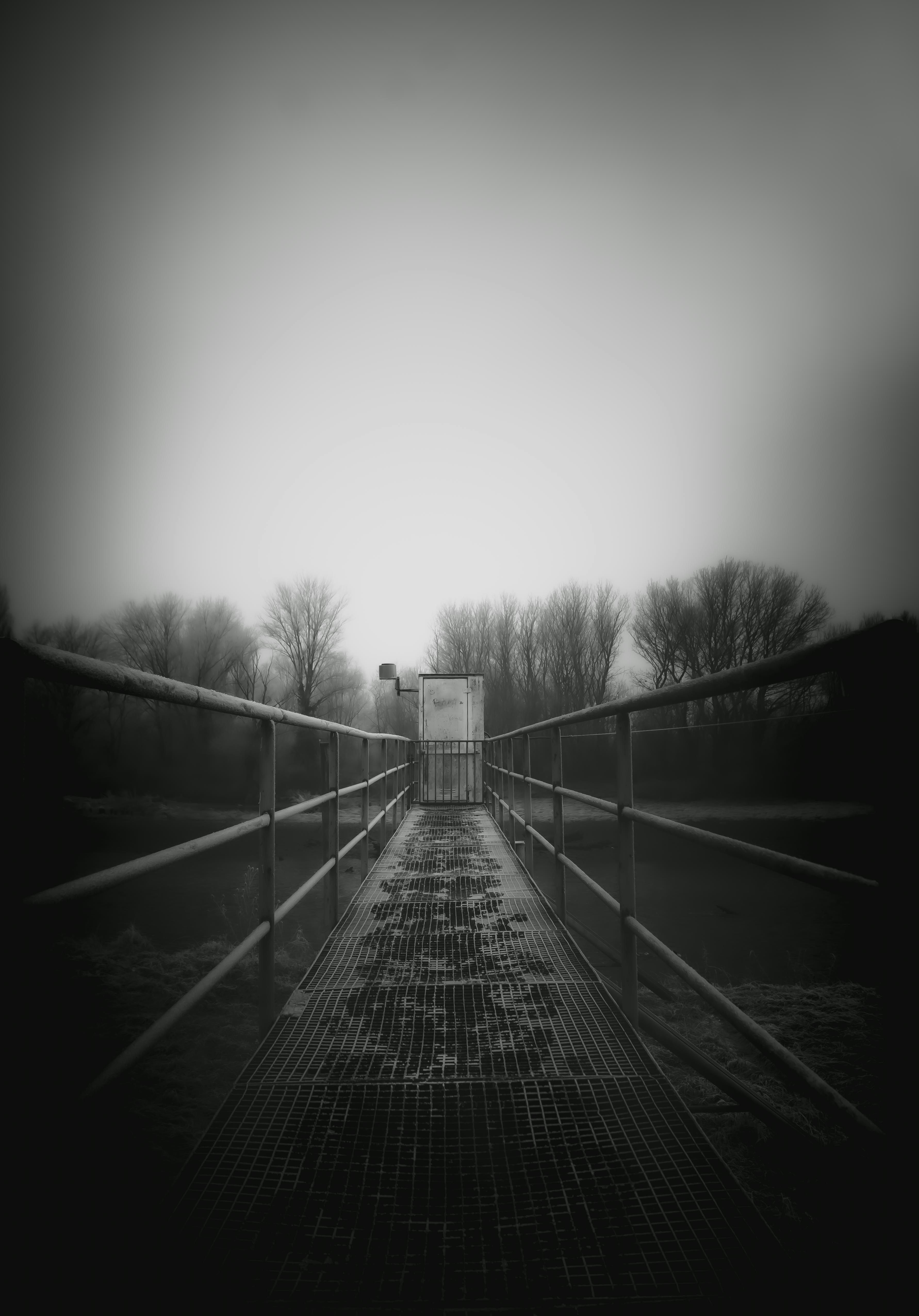 A desolate bridge path under a cloudy sky