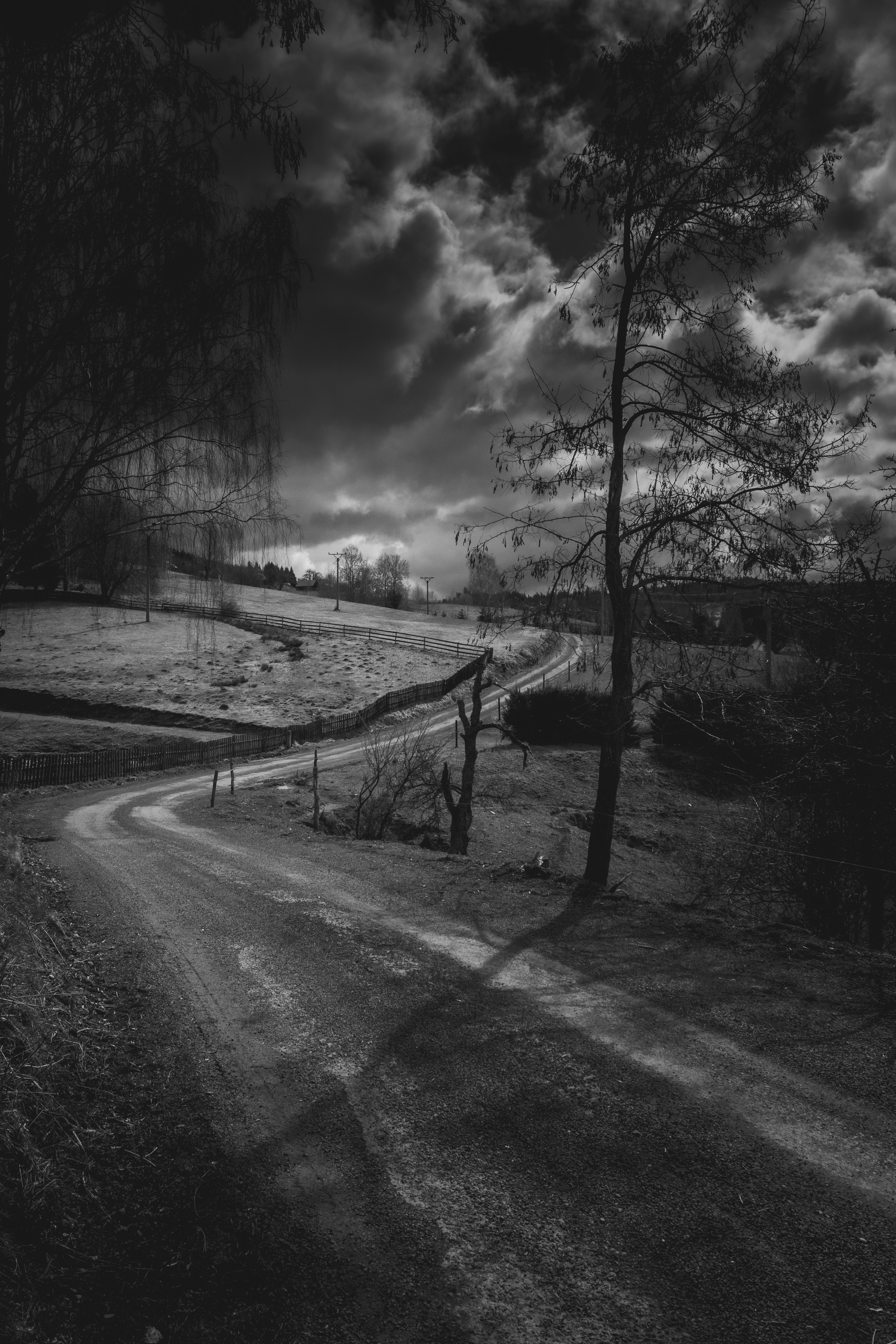 Winding road through a dark, cloudy landscape