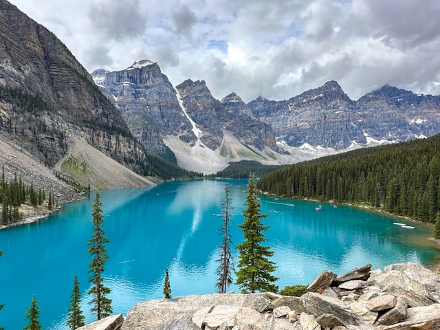 Turquoise lake reflects mountains and pine trees