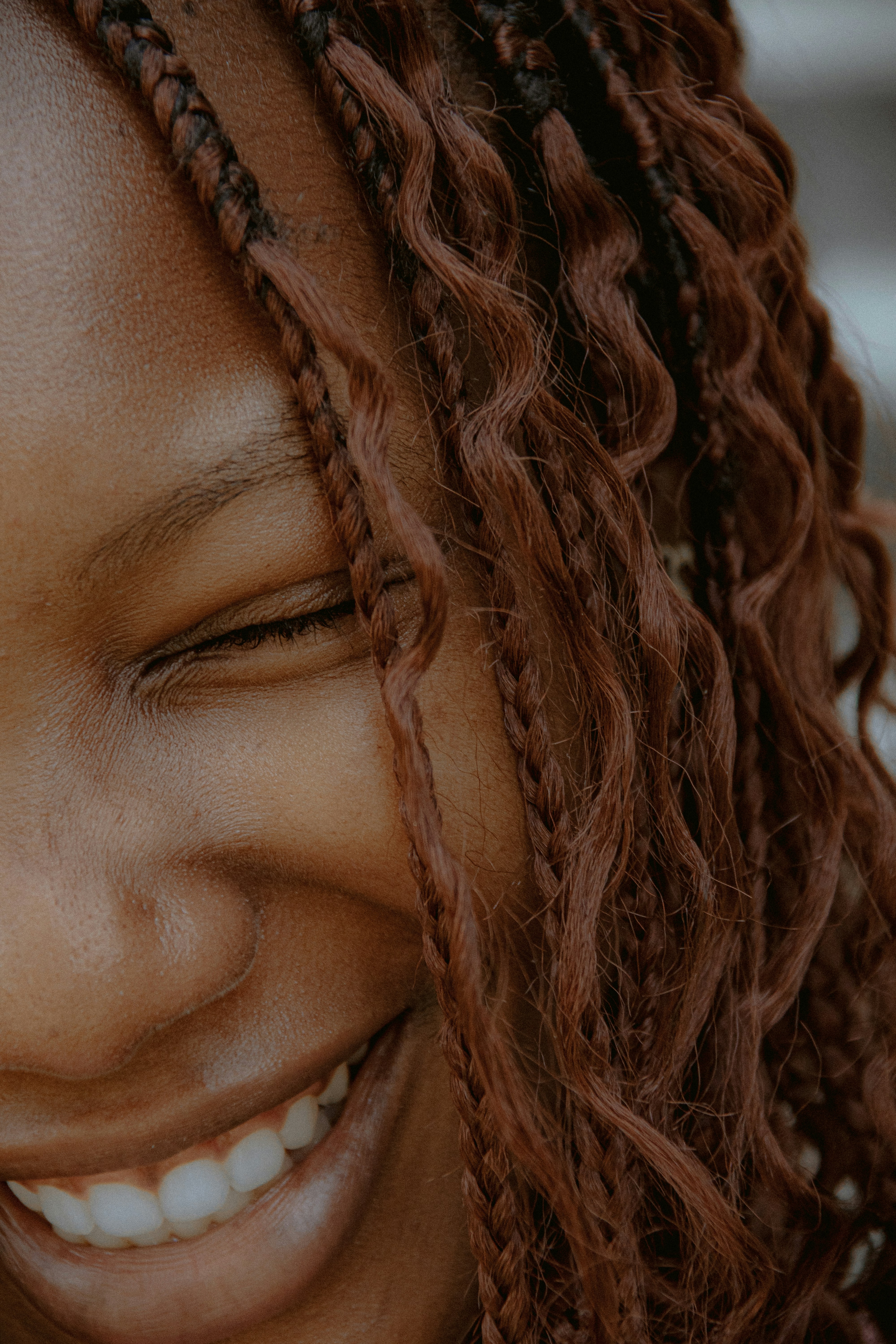 Close-up of a smiling woman with braided hair.