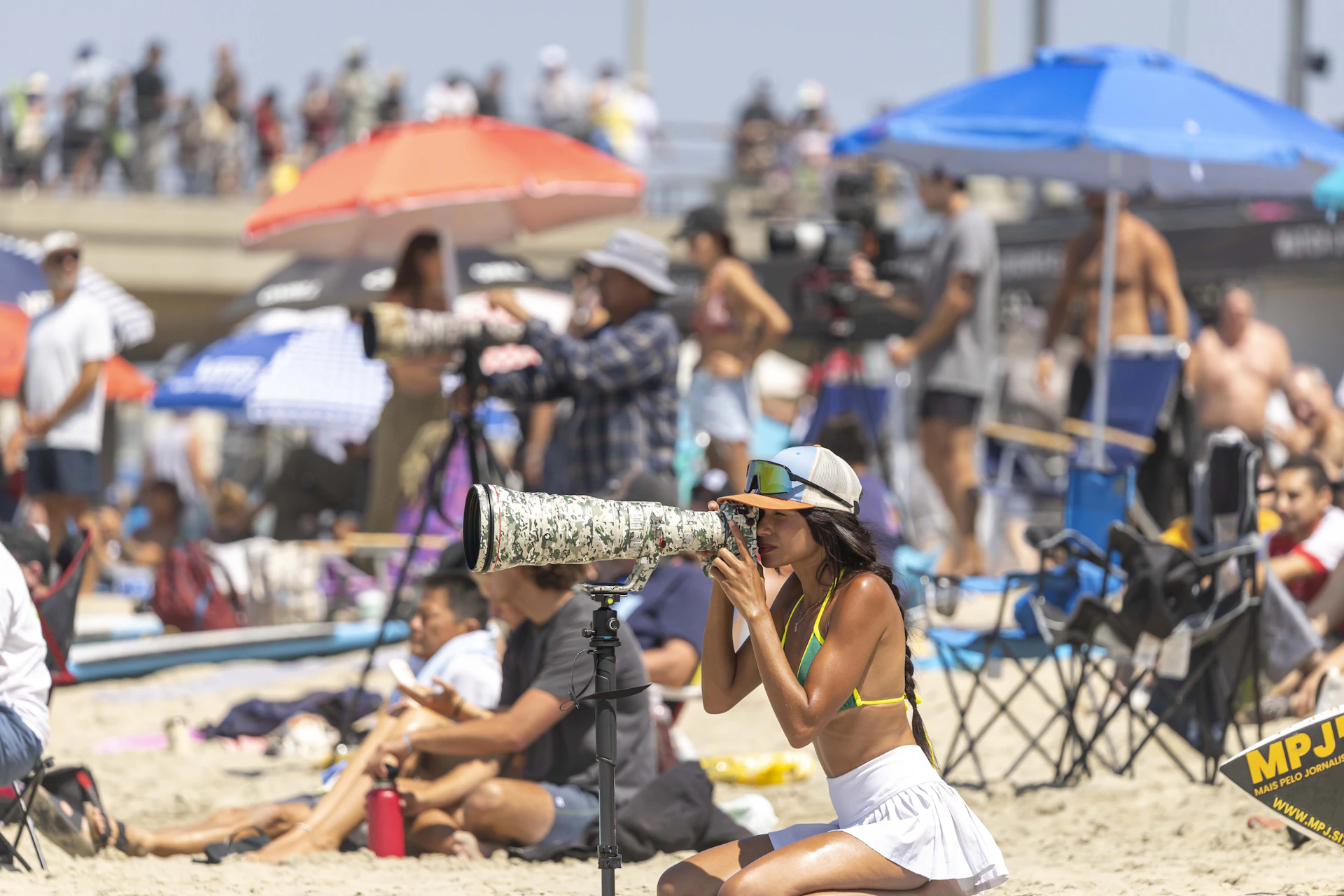 Crowded beach with people relaxing under umbrellas.