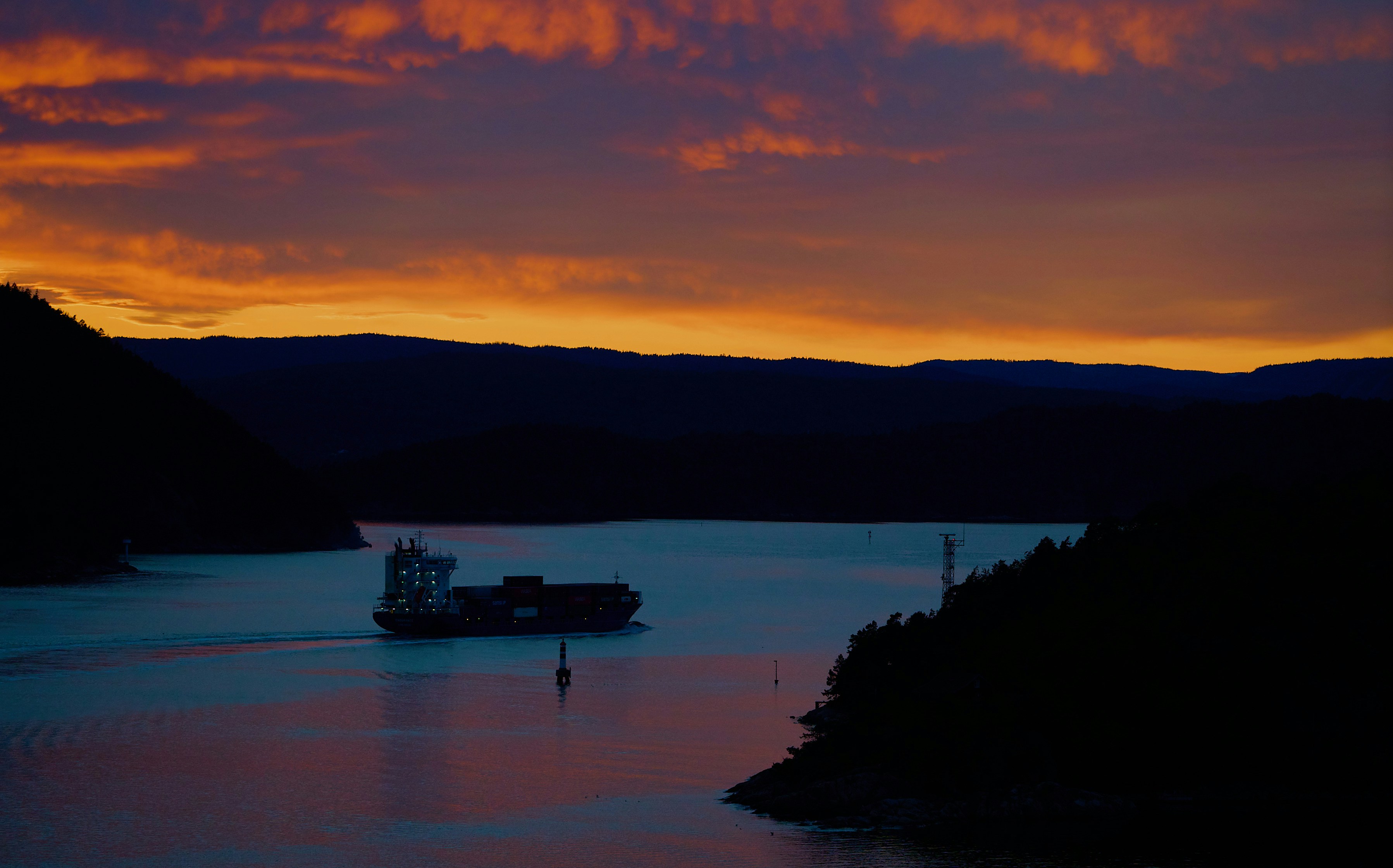 Sunset over a calm lake with distant hills