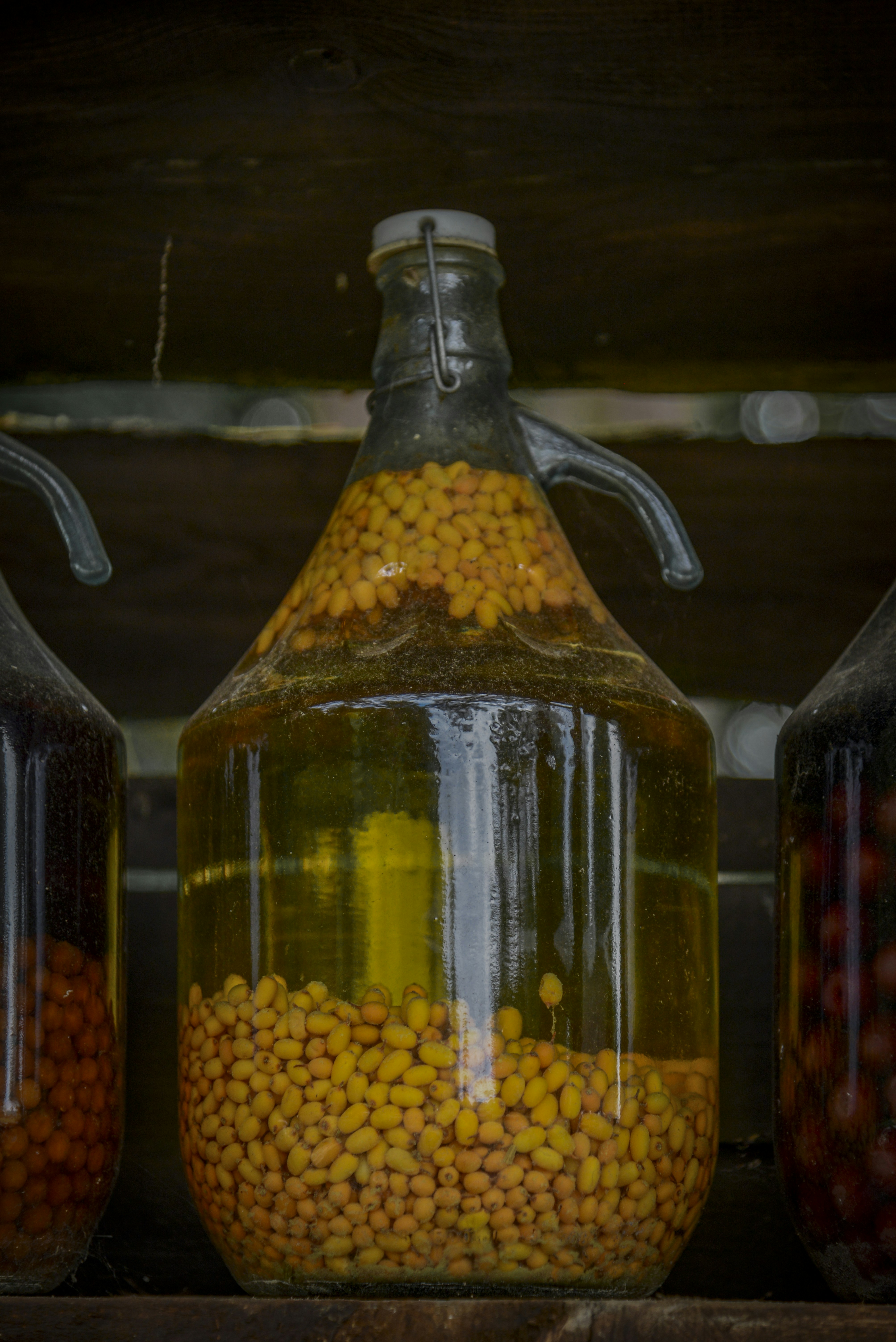 Large glass jug filled with yellow seeds