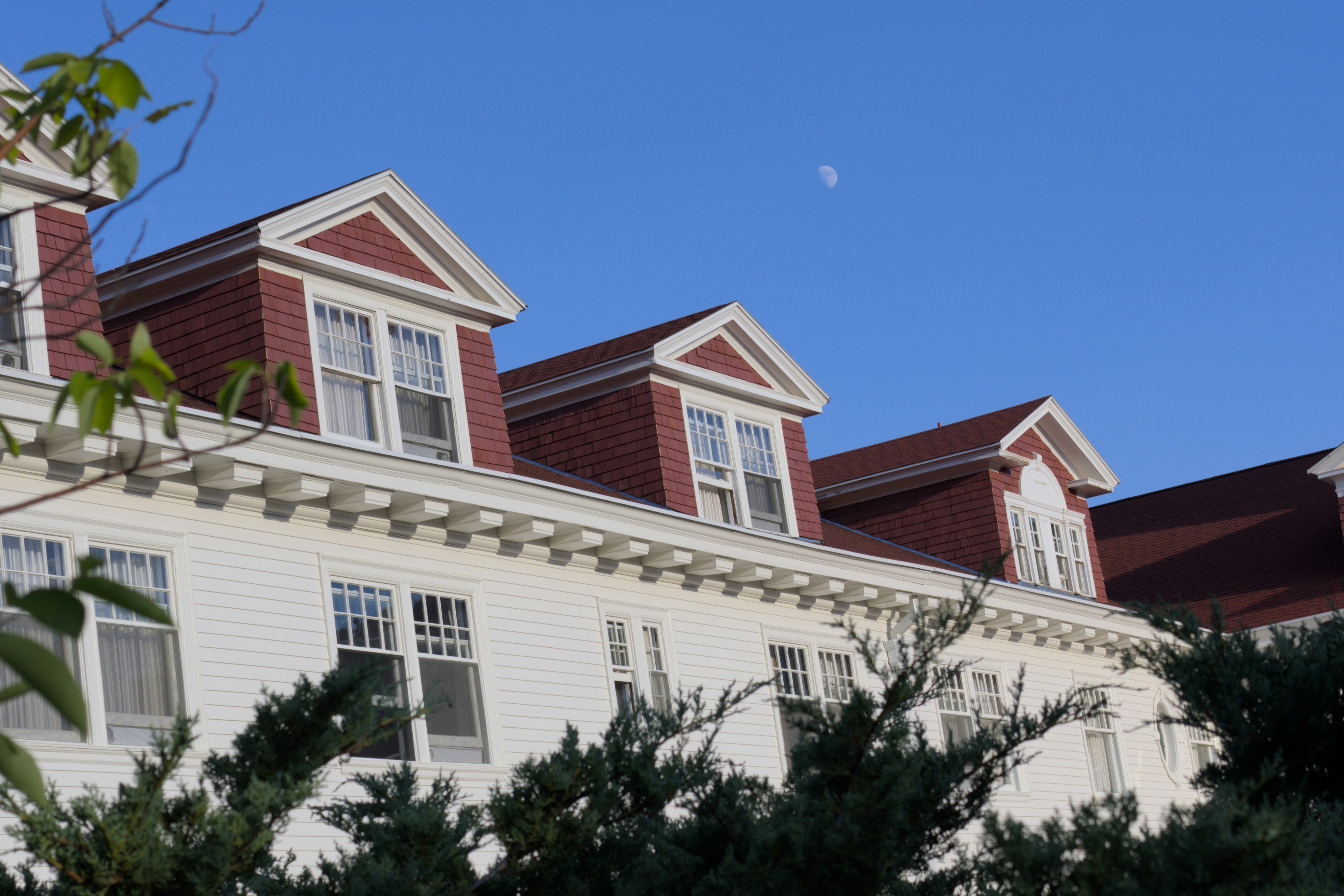 White building with red roof and dormer windows