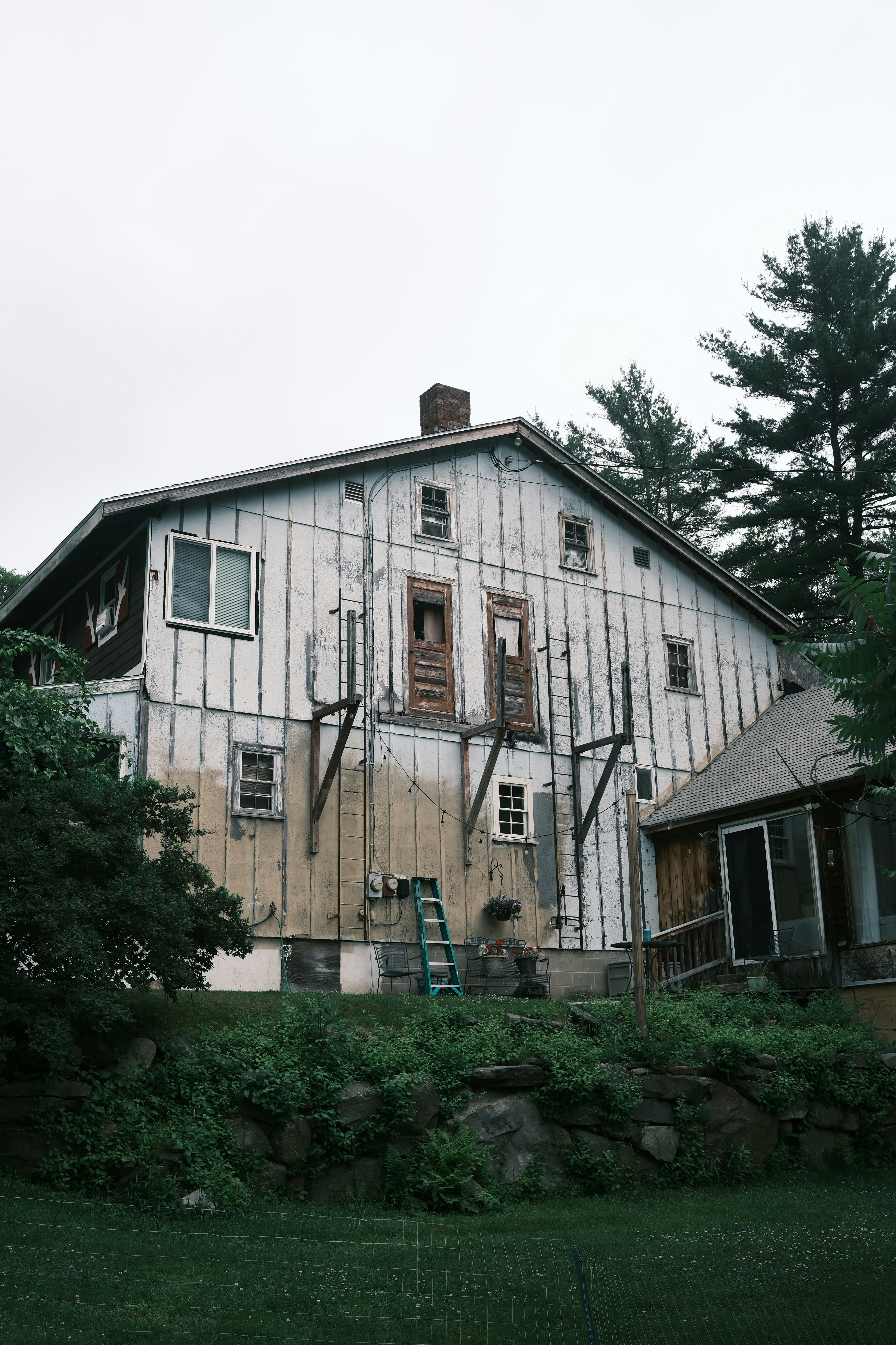Old white wooden barn with a porch attached