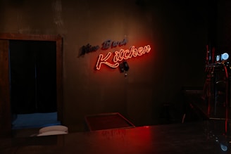 Orange neon sign glowing in a dark room