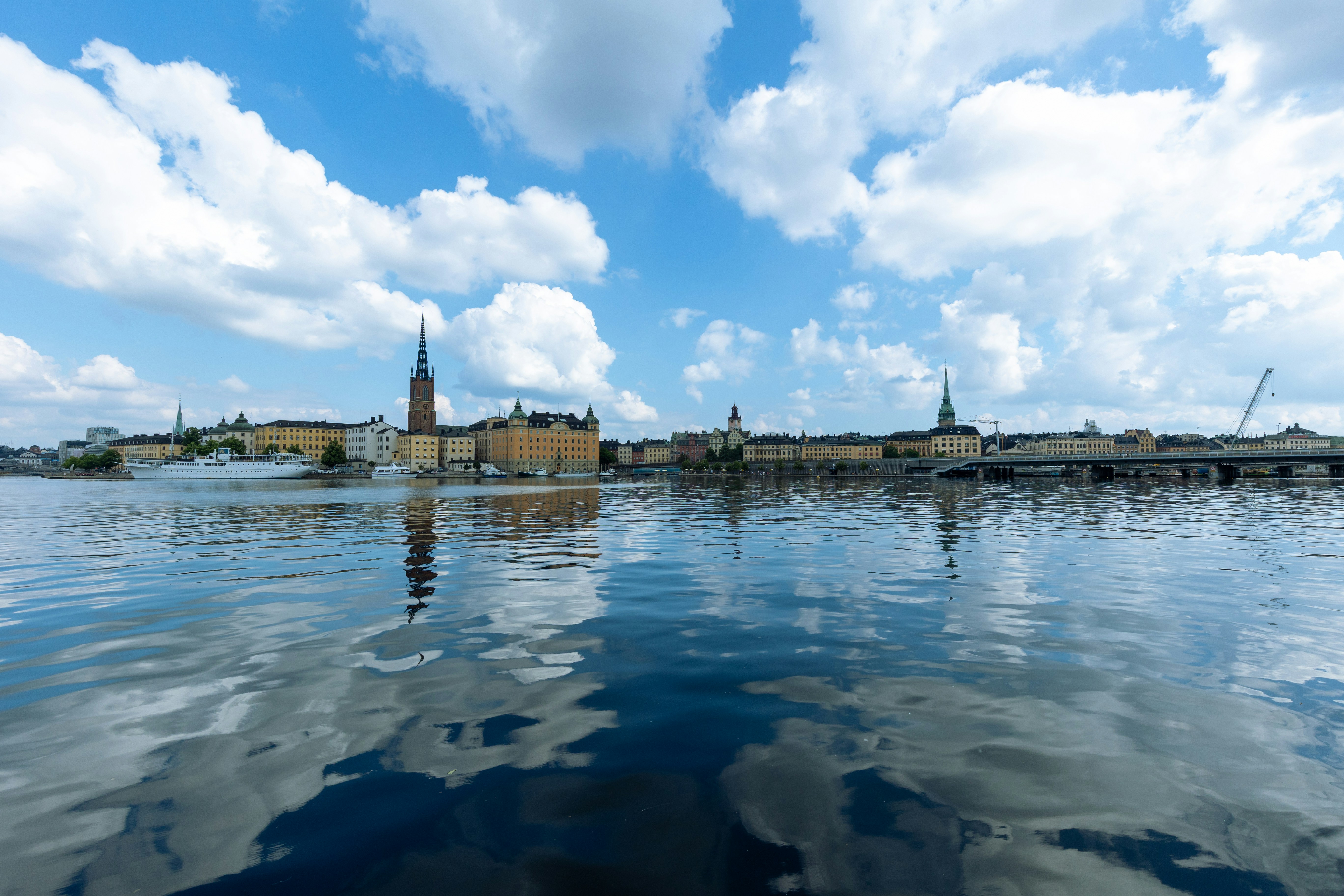 City skyline reflected in calm water under cloudy sky