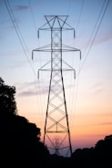 Tall power line tower against a sunset sky