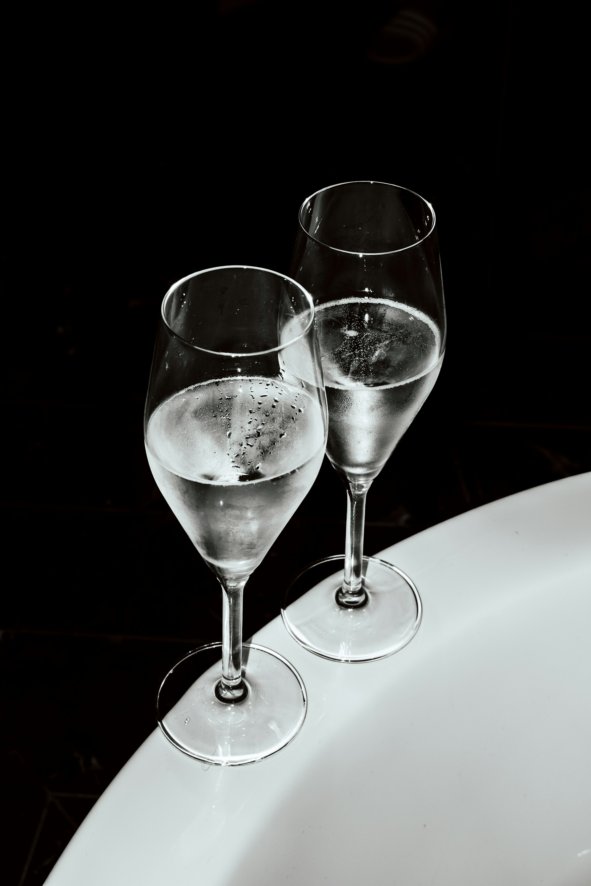 Two wine glasses filled with clear liquid.