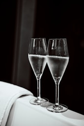 Two glasses of champagne on a white surface