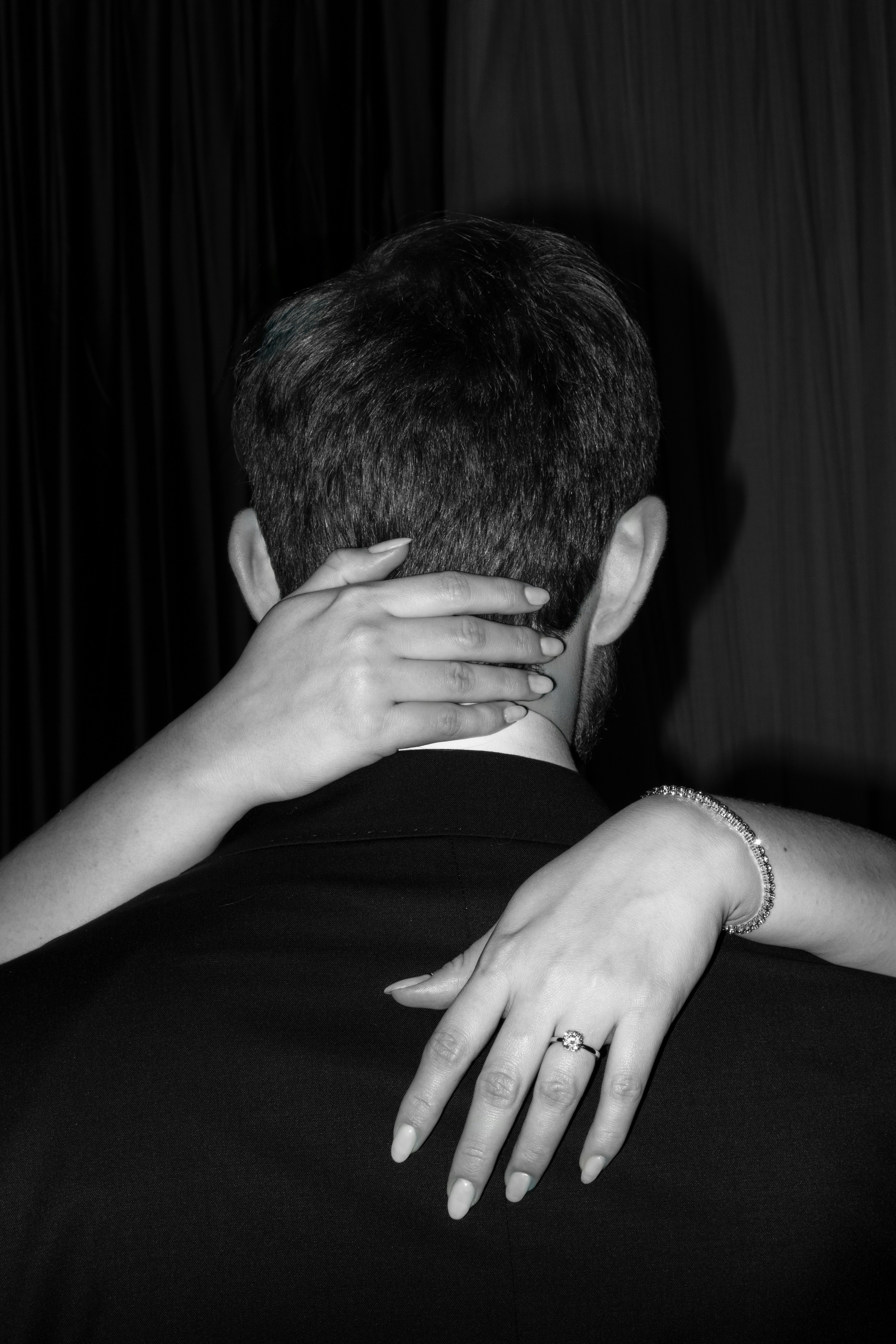 Woman's hands embracing man's neck and shoulder