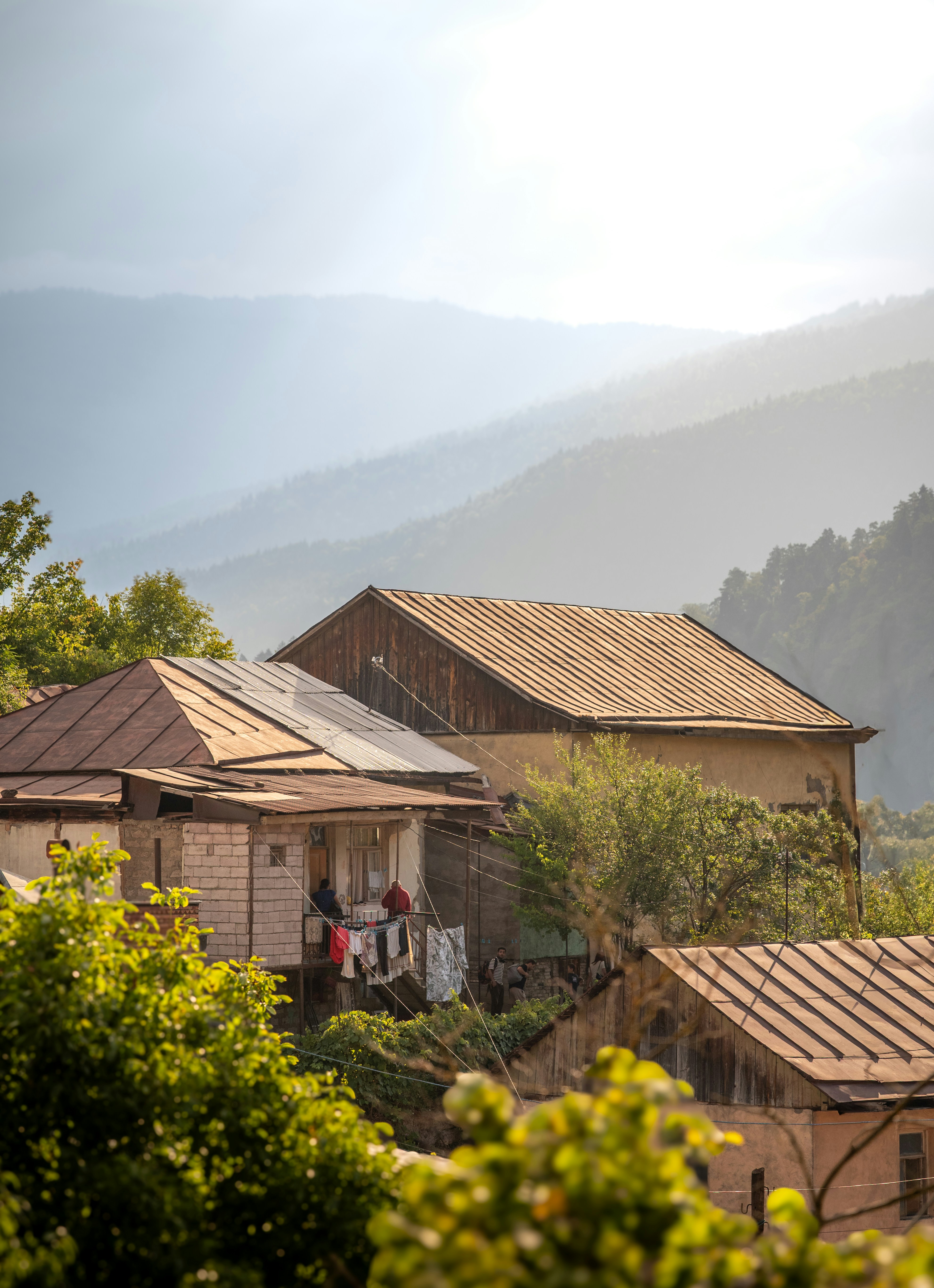 Rustic village nestled among rolling hills at sunrise.