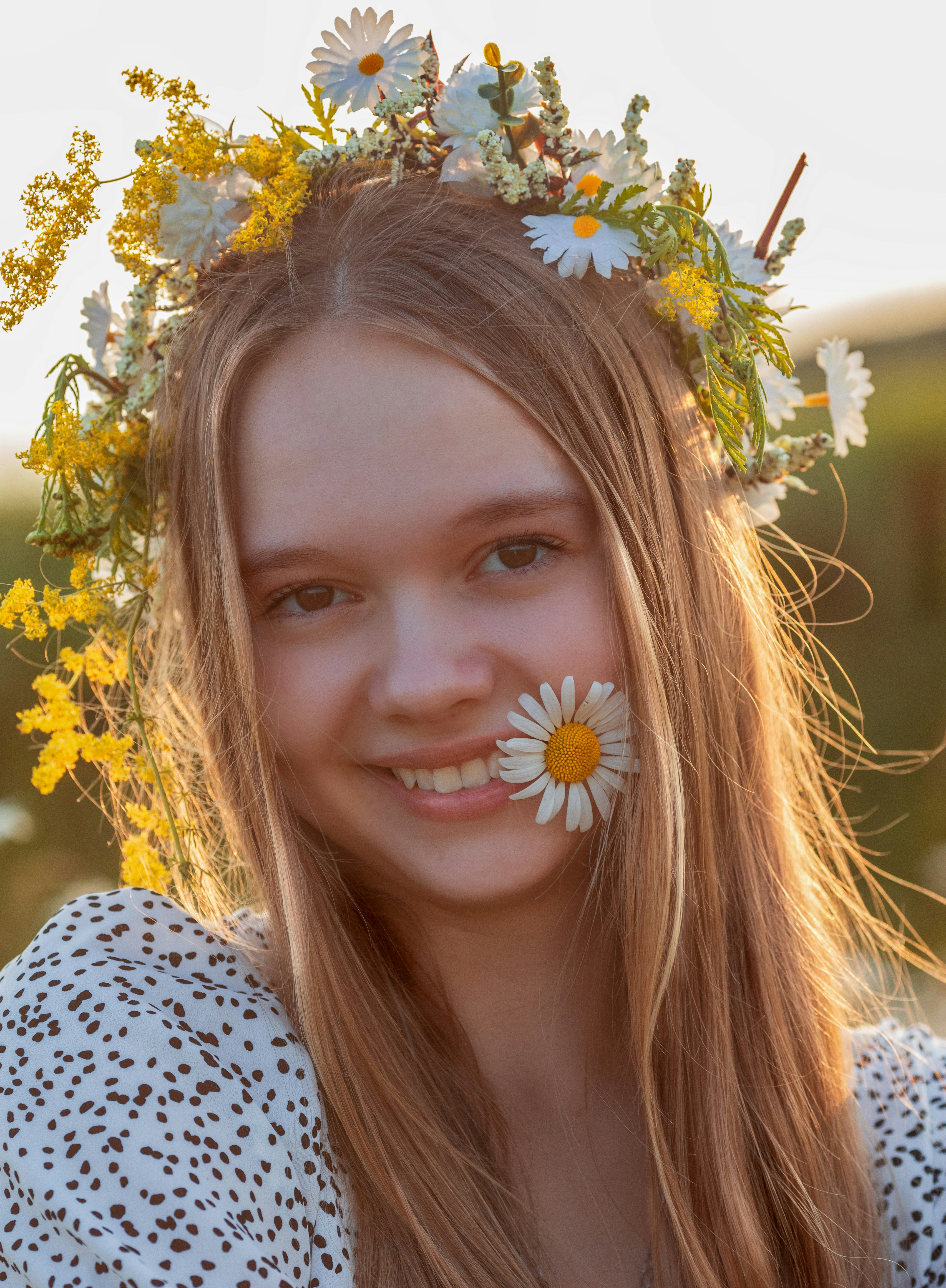 Young woman wearing a flower crown and daisy
