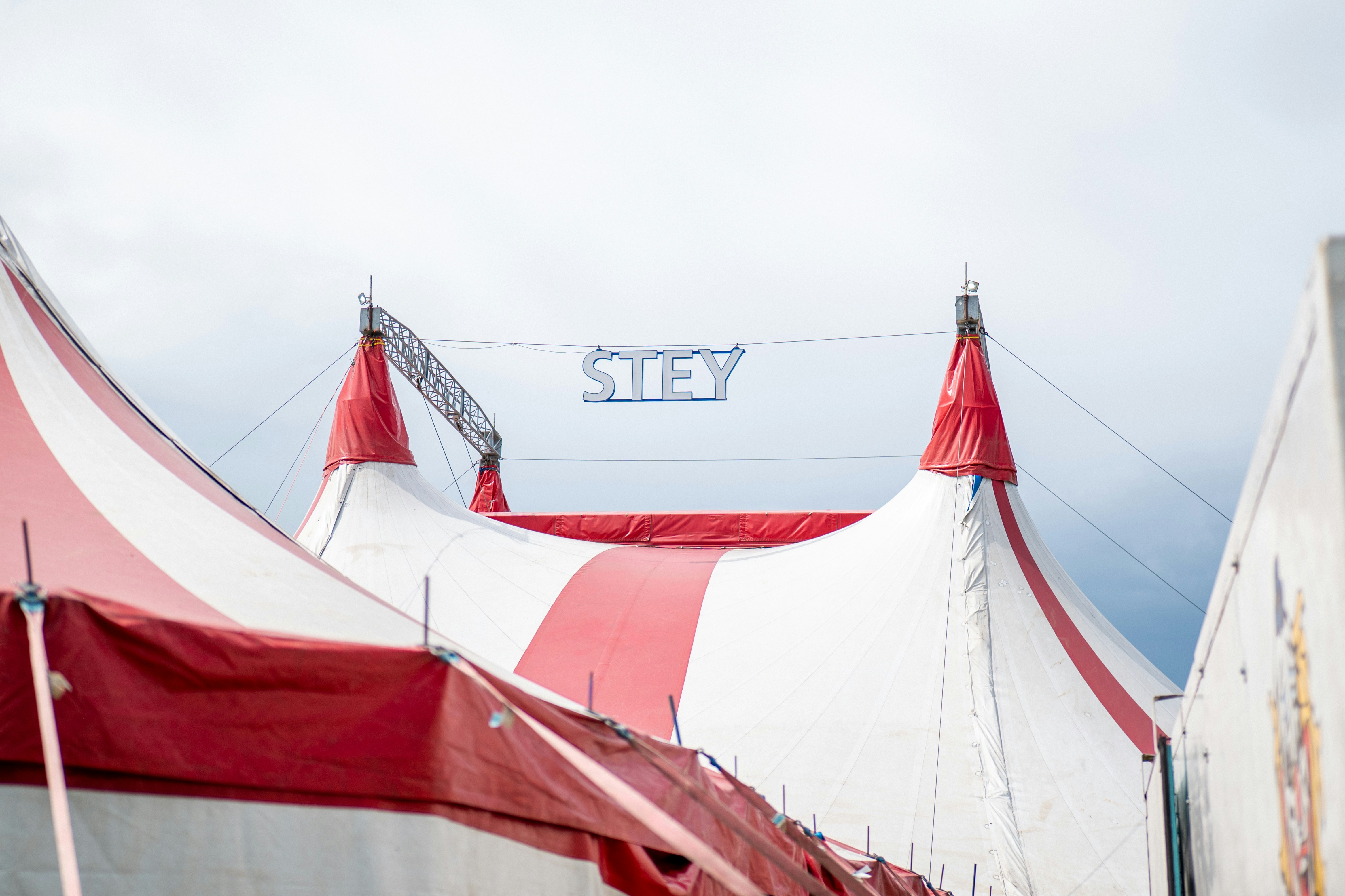 Circus tents with red and white stripes under sky