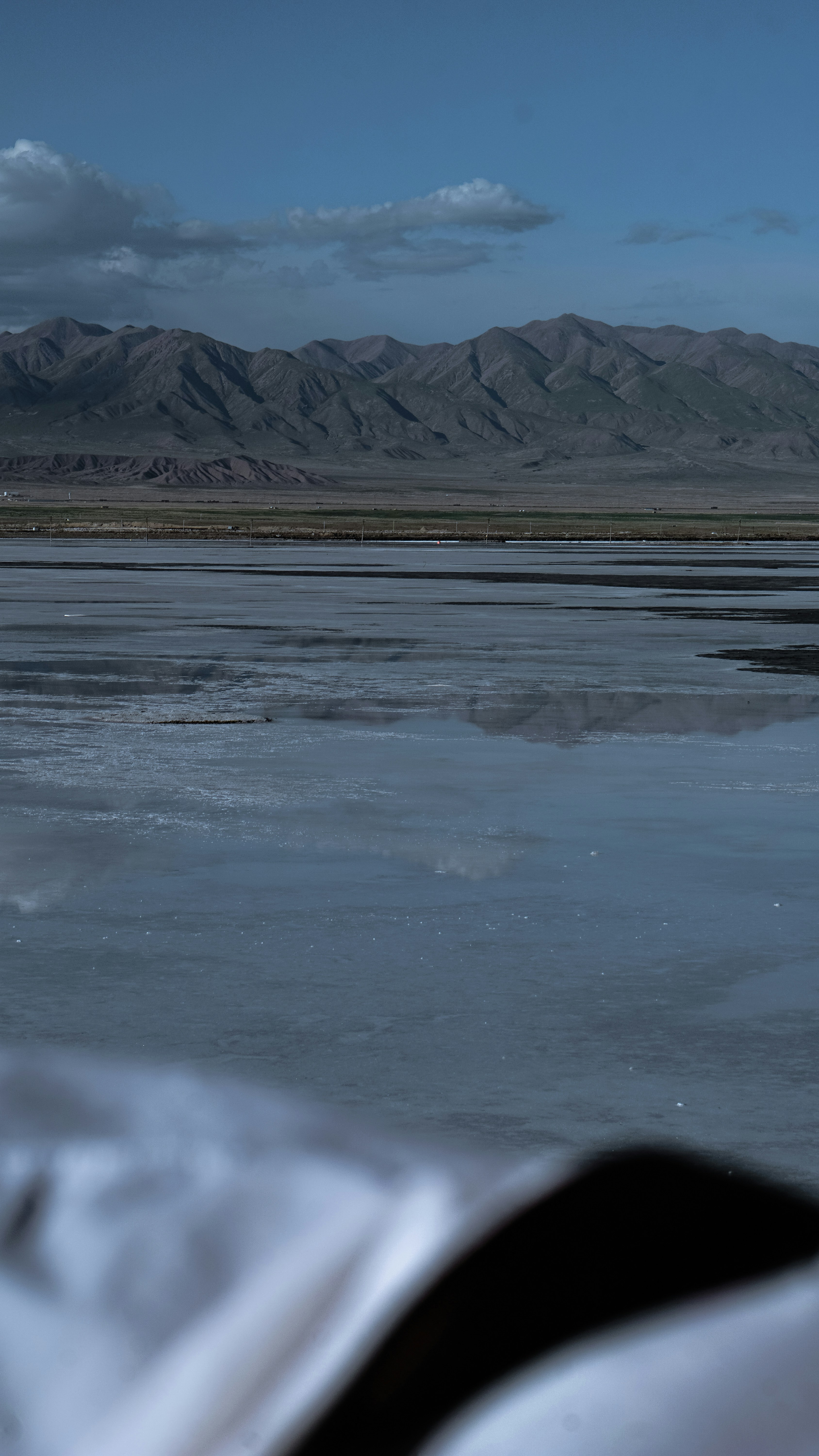 Mountain range reflected in a calm lake under sky